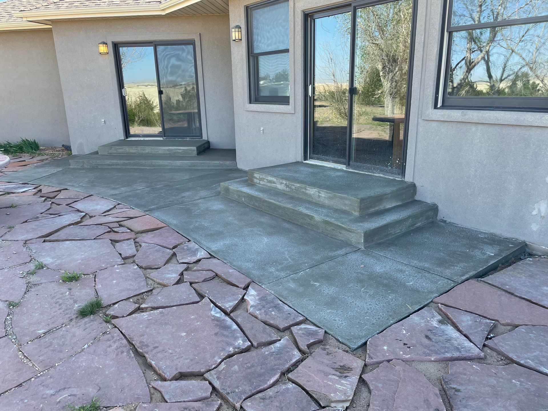 A house with a patio and stairs in front of it.