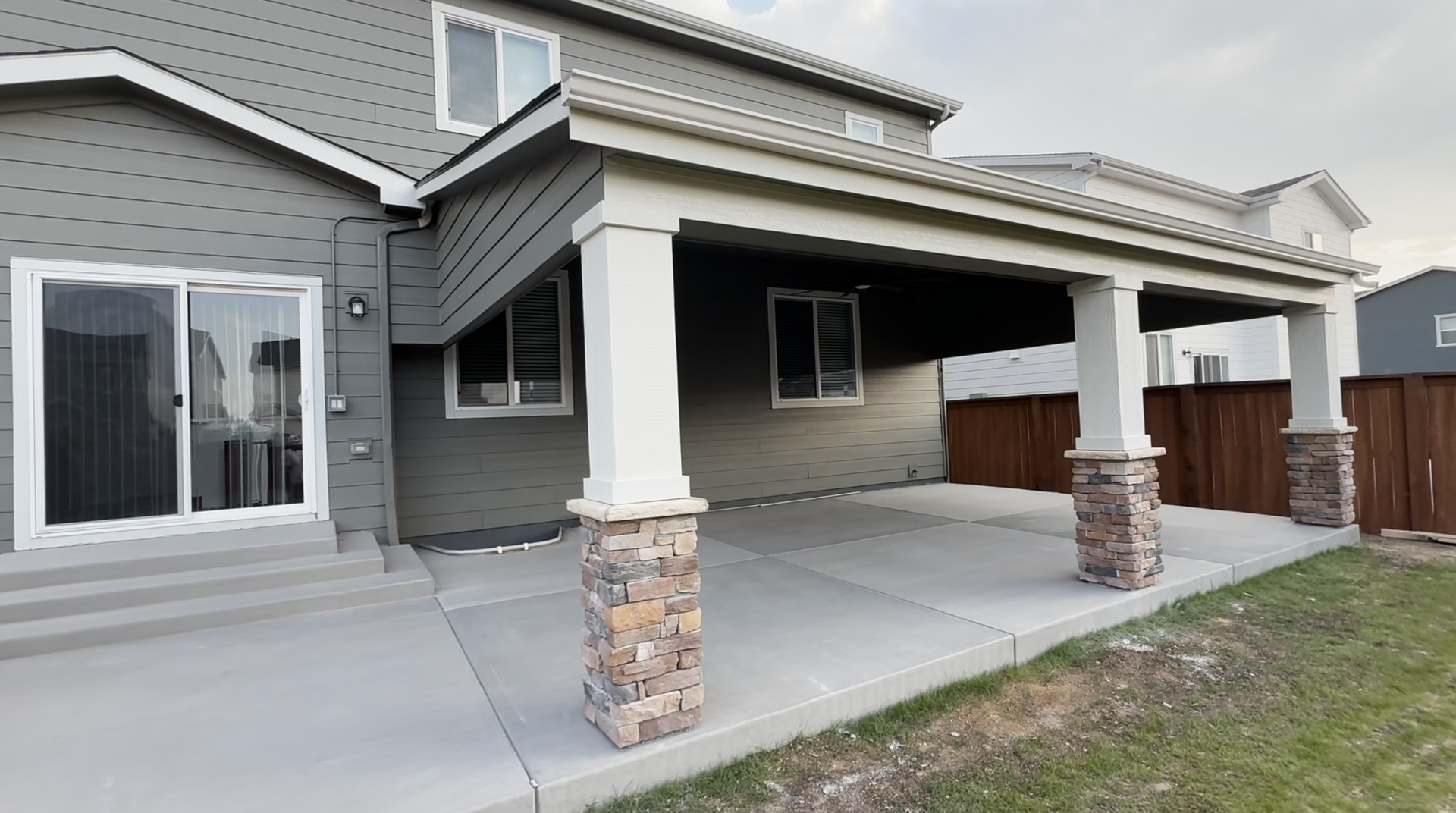 A group of construction workers are working on a concrete driveway.