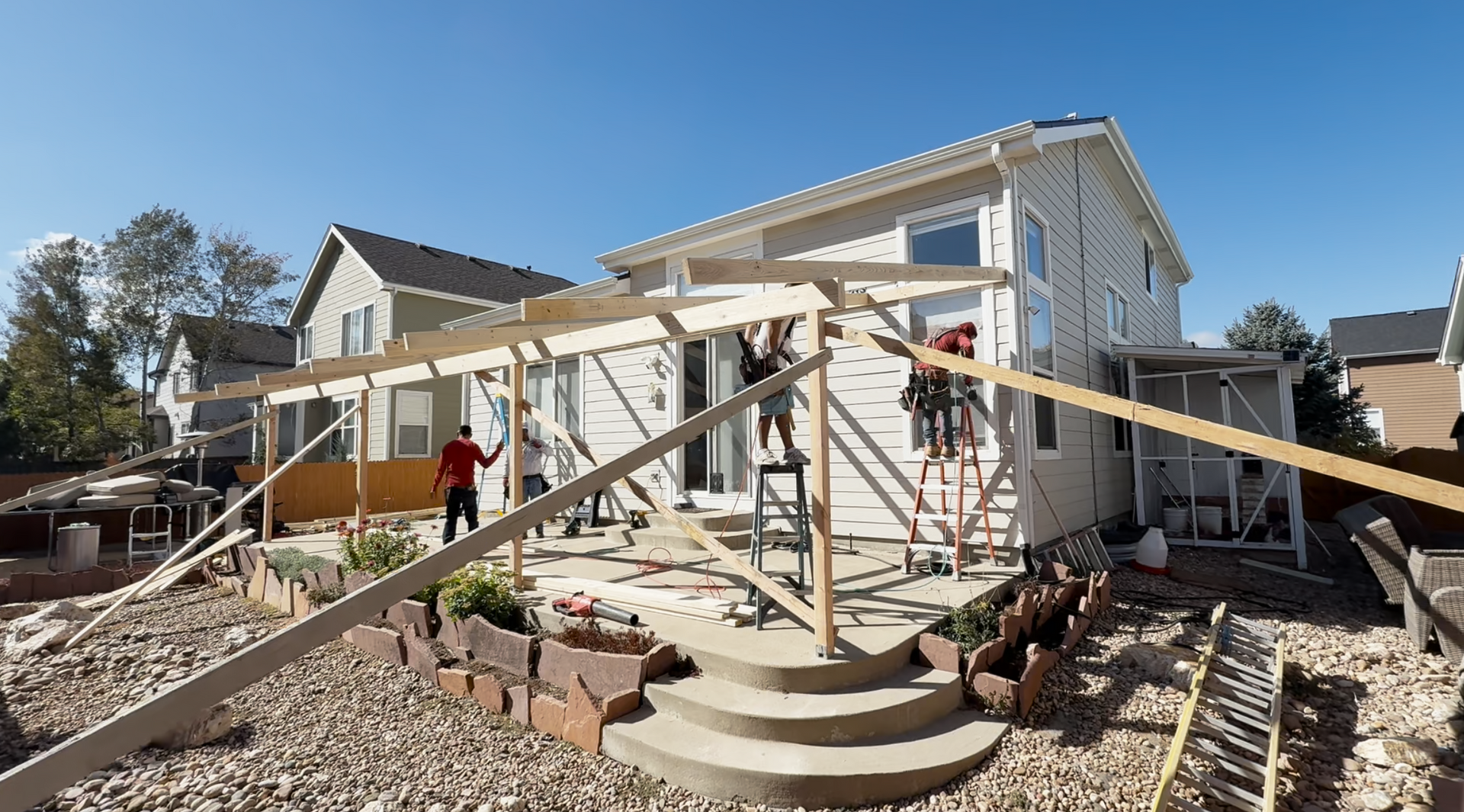 A group of construction workers are working on a concrete driveway.