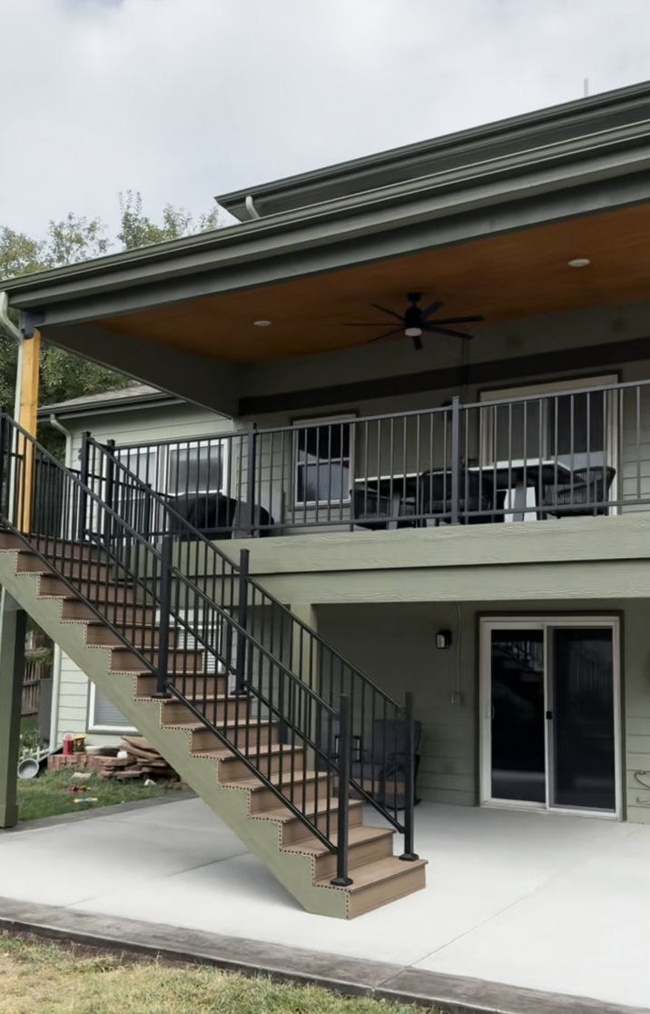A concrete walkway is being built in a backyard with a wooden fence in the background.