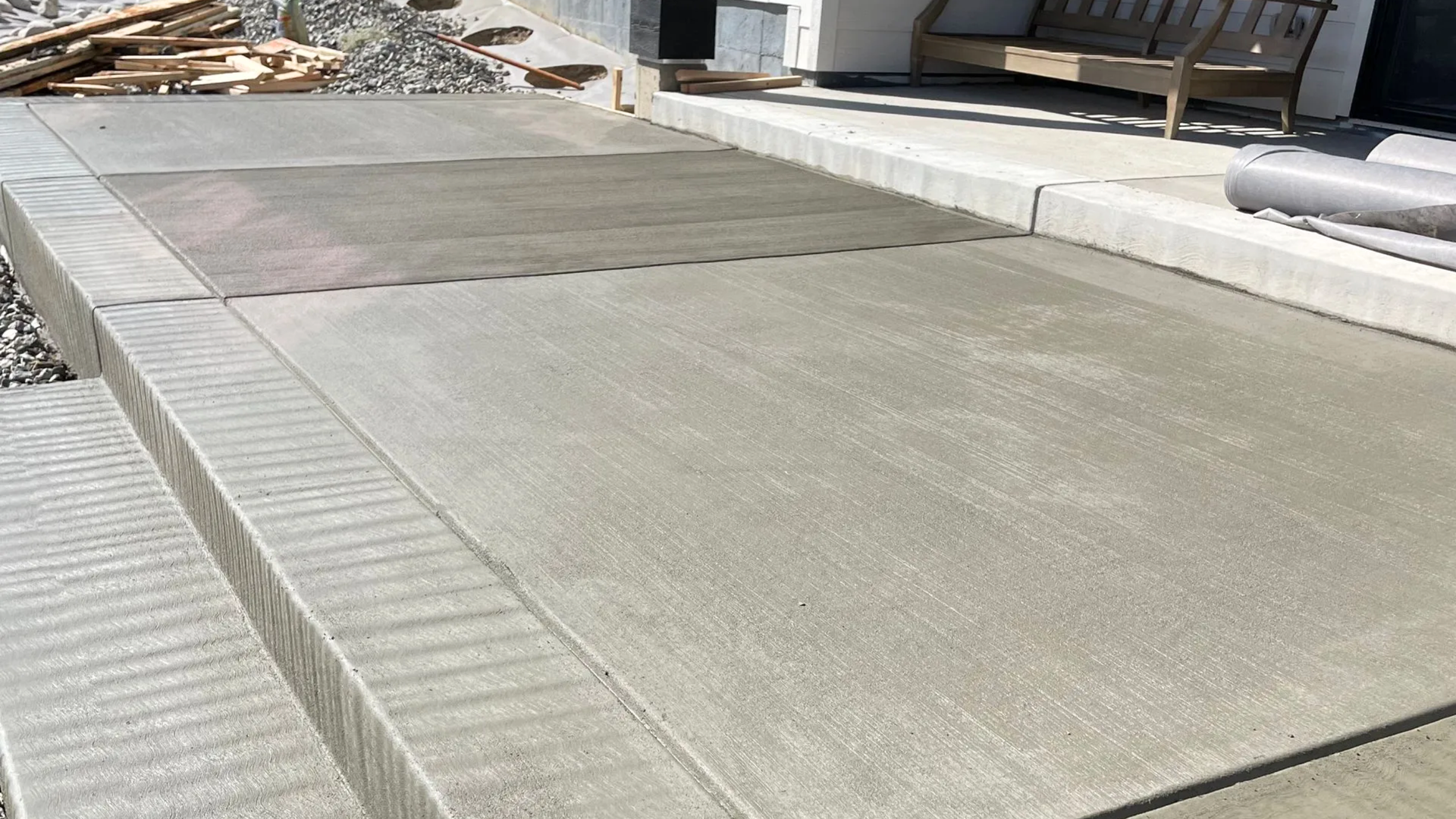 Newly poured concrete patio with broom finish and steps installed by ANE Concrete in Brighton CO