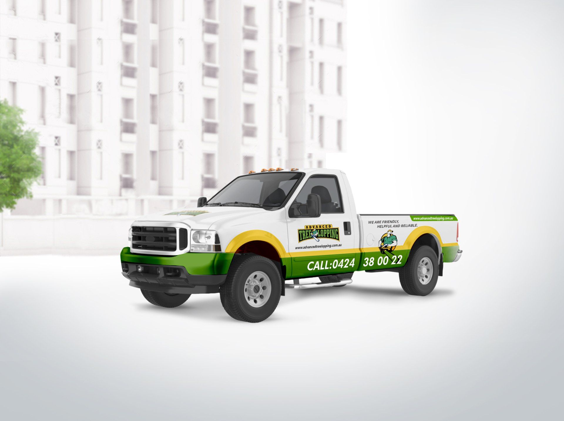 A white truck with a green and yellow stripe on the side is parked in front of a building