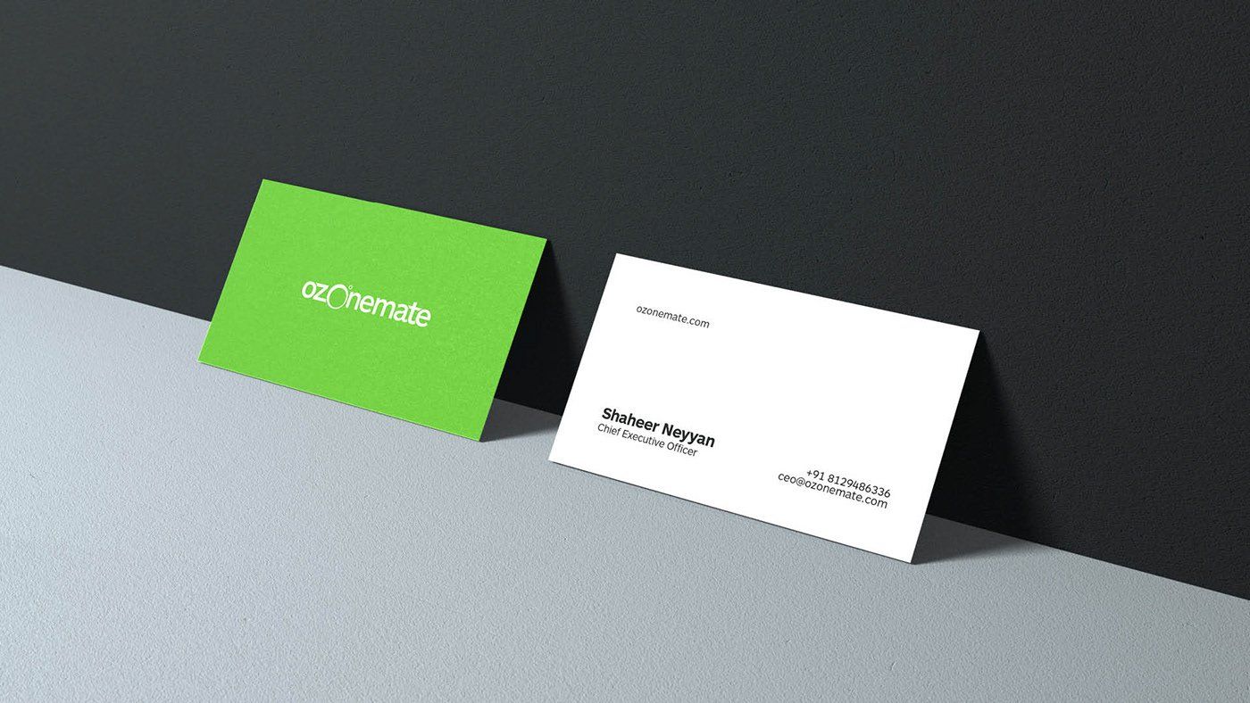 A green business card and a white business card are sitting next to each other