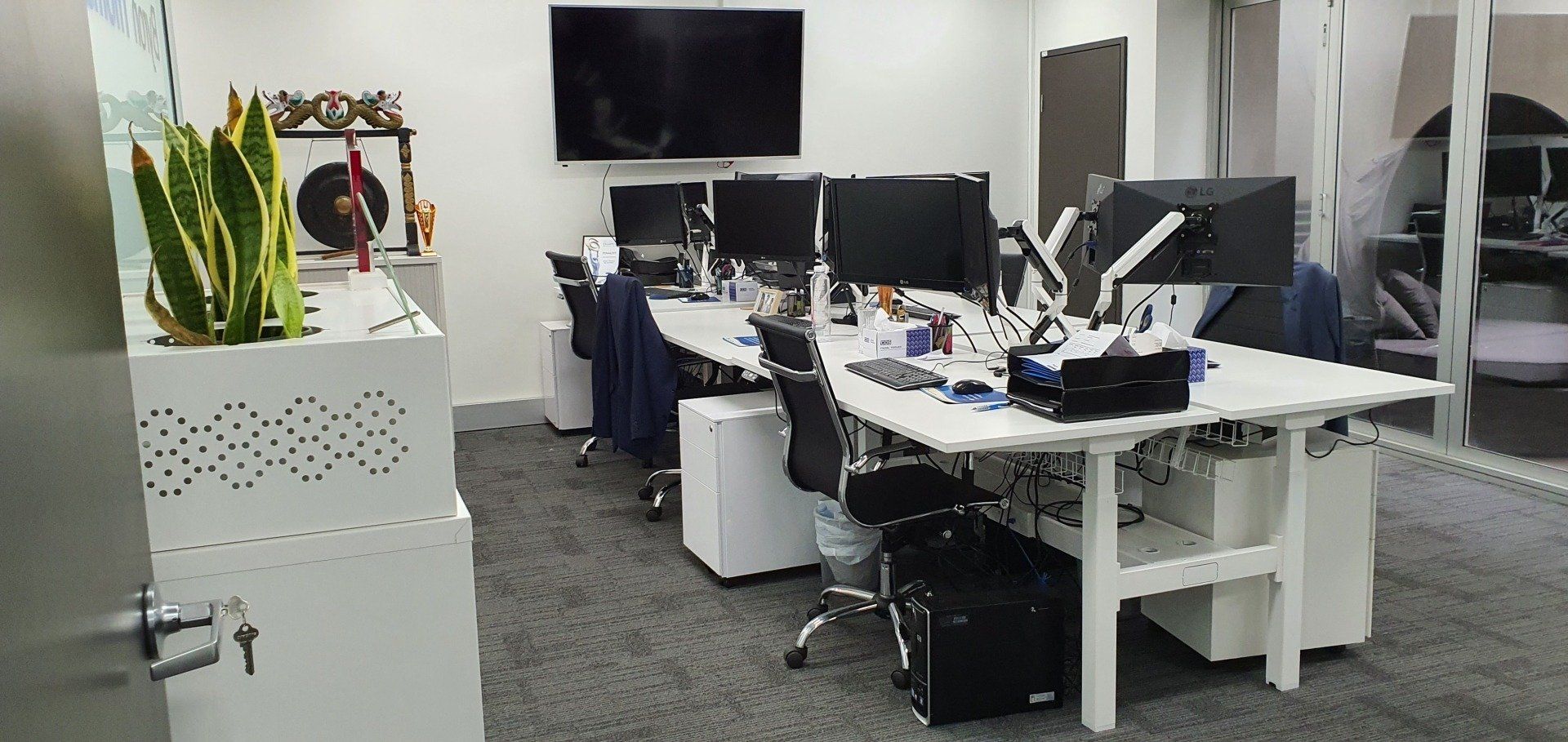 A large office with a lot of desks and monitors