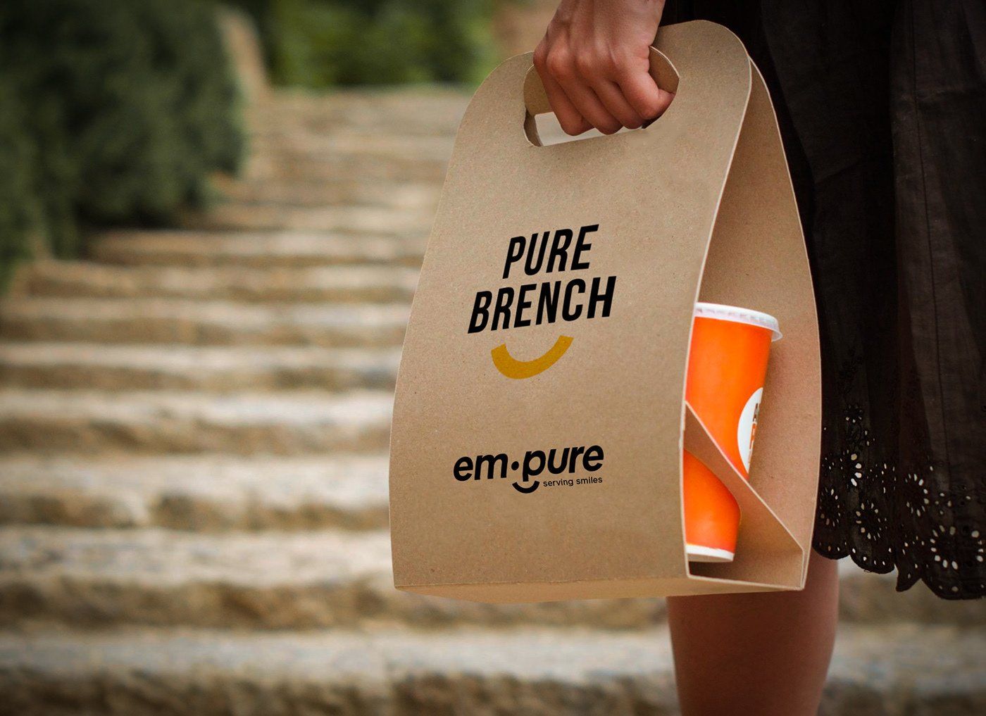 A person holding a bag that says pure brunch on it