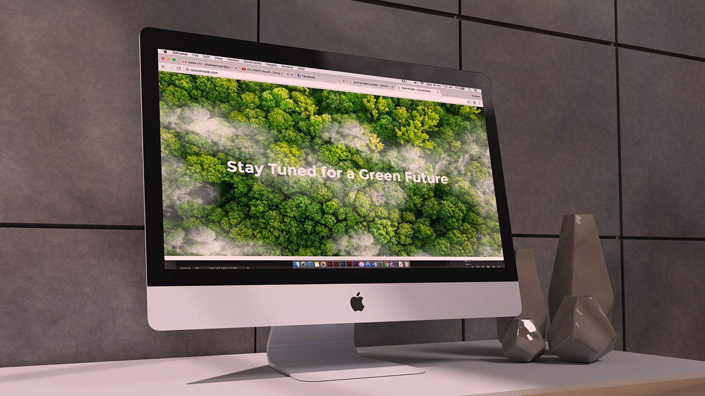 An apple computer displays a blurred image of a forest