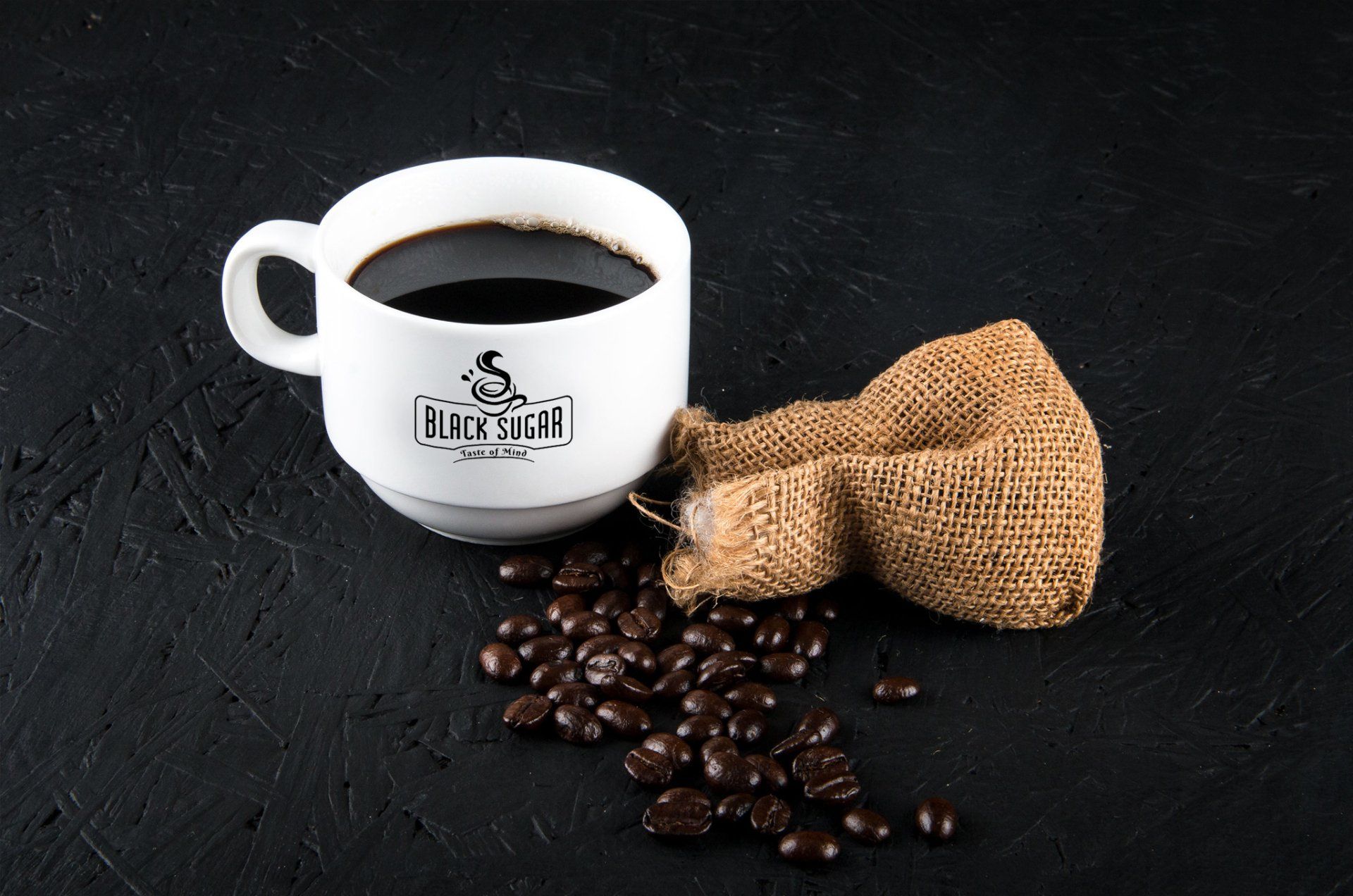 A cup of coffee next to a bag of coffee beans