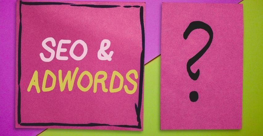 A pink sign that says seo and adwords next to a question mark.