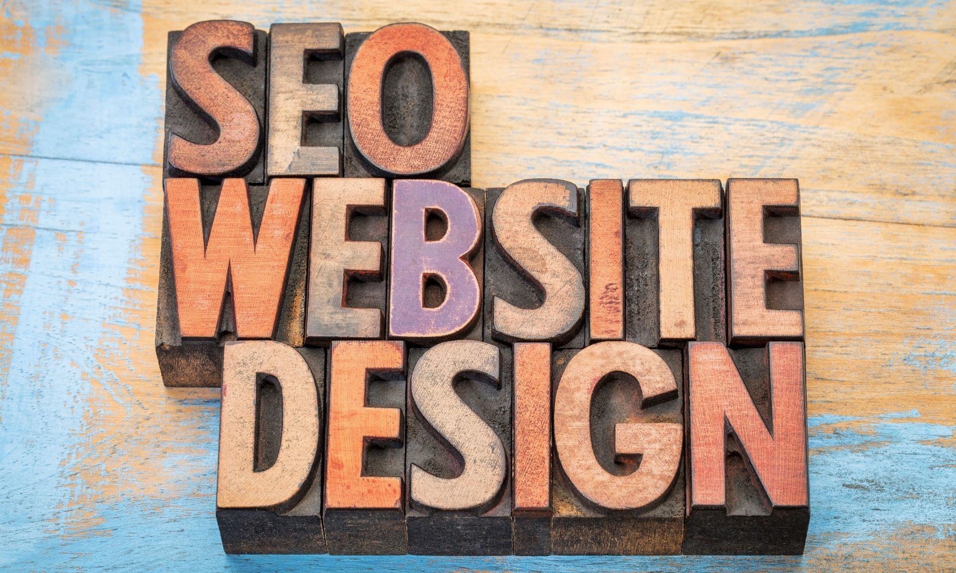 The word seo website design is written in wooden letterpress type.