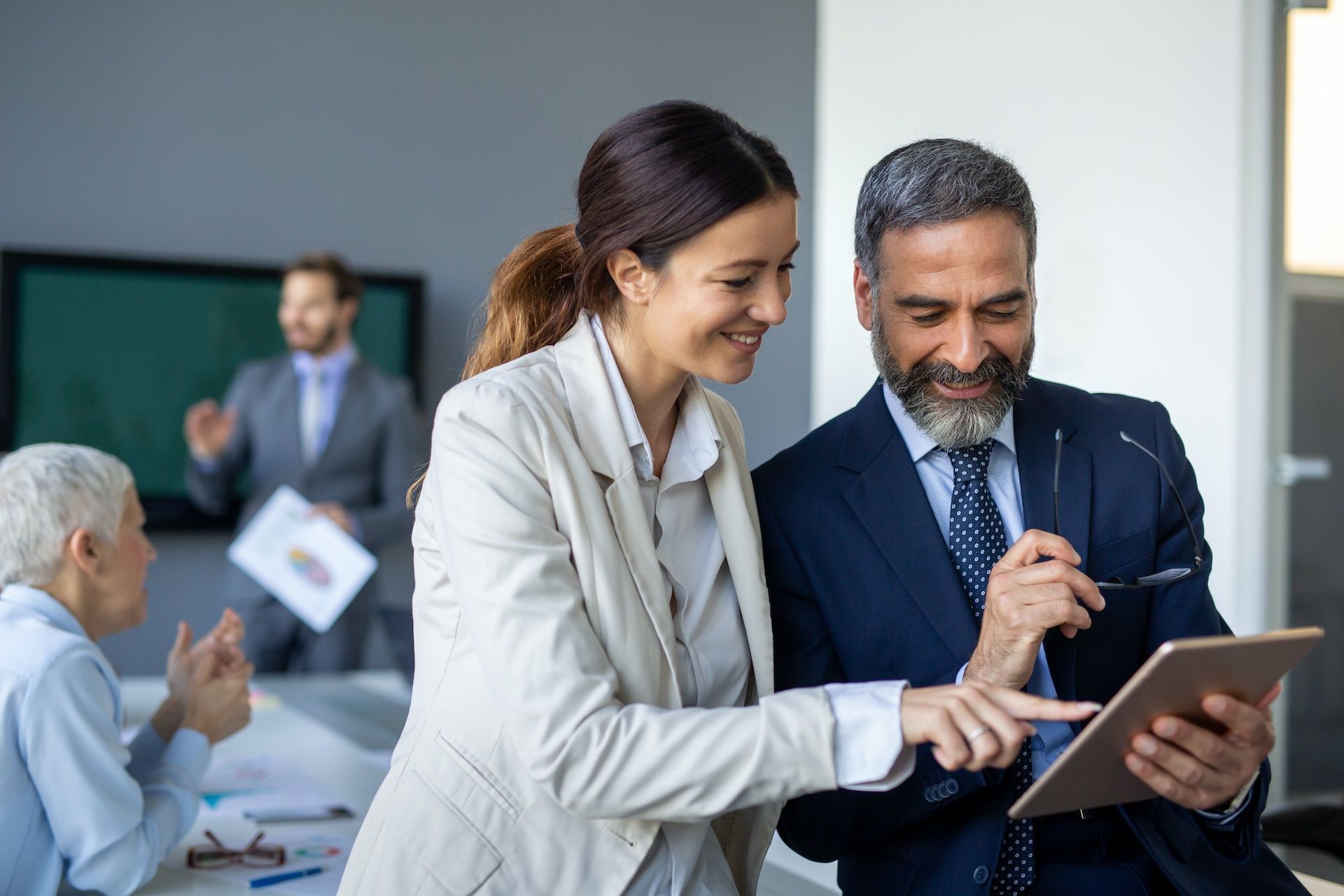 A man and a woman are looking at a tablet together.