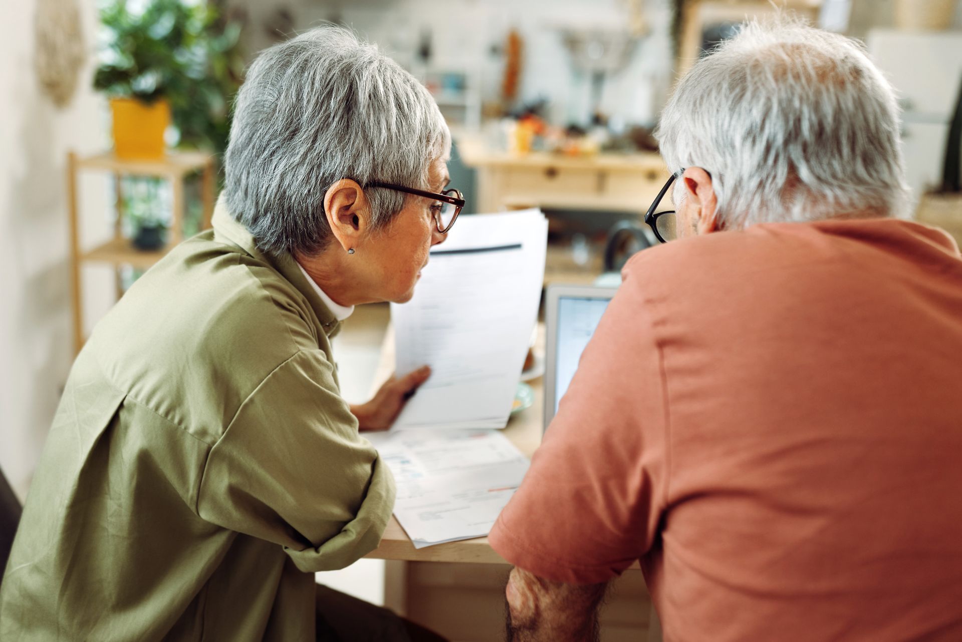 A man and a woman are sitting at a table looking at papers.