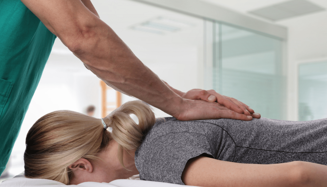 A woman is laying on a bed getting a massage from a man.