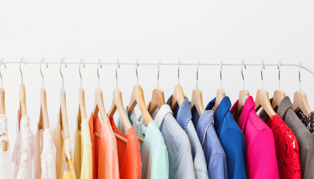A row of colorful clothes hanging on a rack.