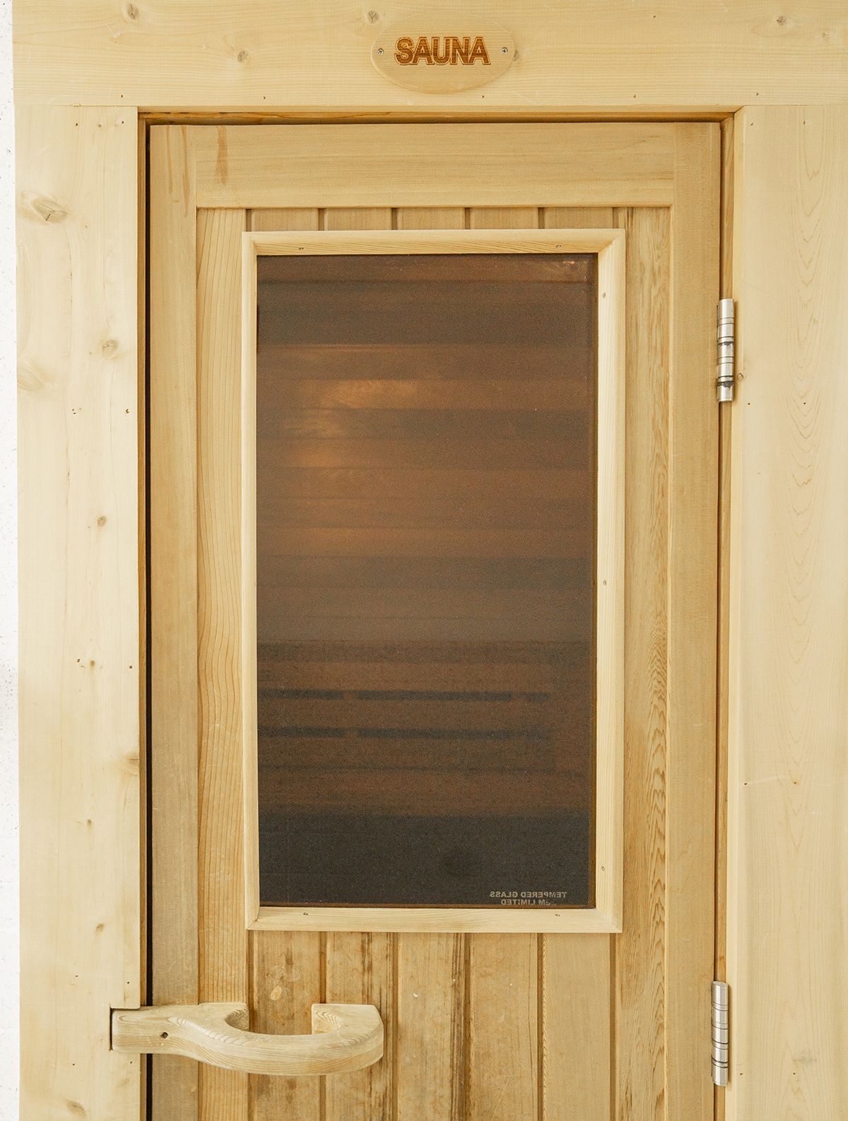 A wooden door with the word sauna on it
