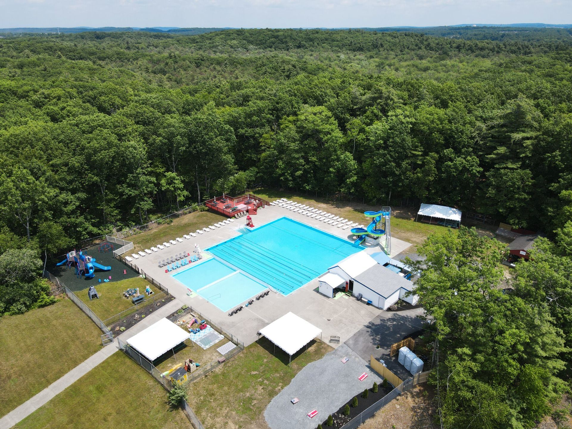 An aerial view of a large swimming pool surrounded by trees.