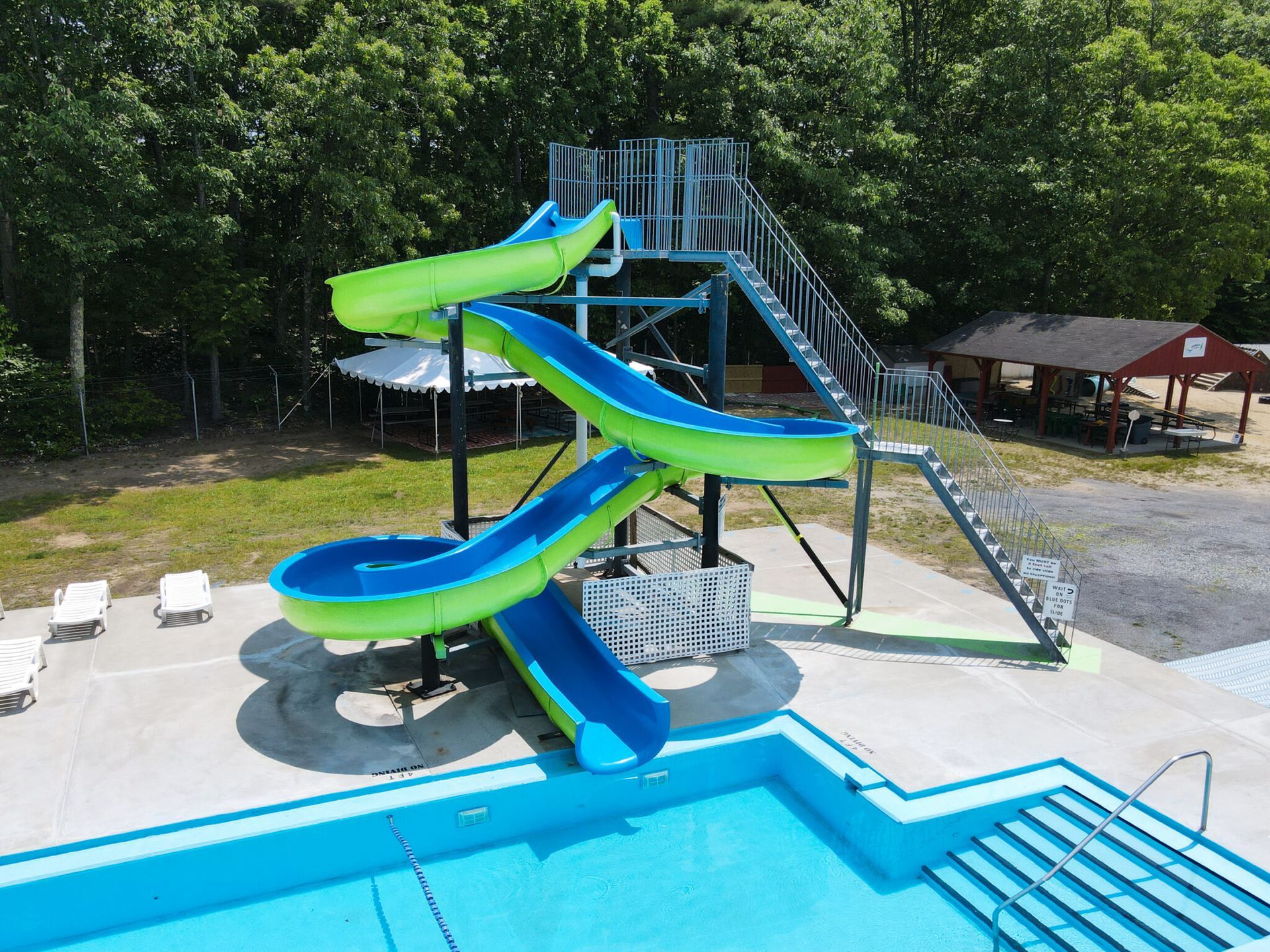 An aerial view of a water slide next to a swimming pool.