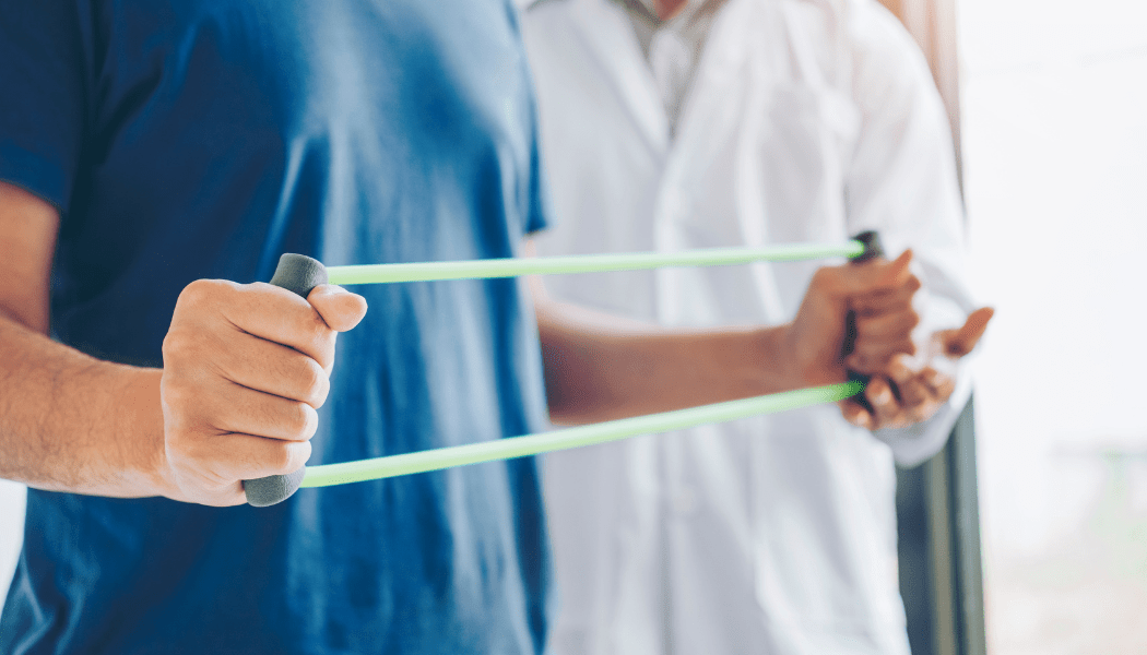 A man is being helped by a nurse with a resistance band.