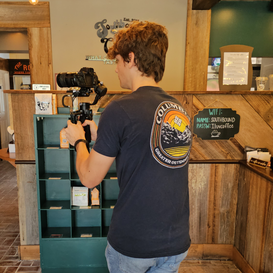 A man in a black shirt is holding a camera