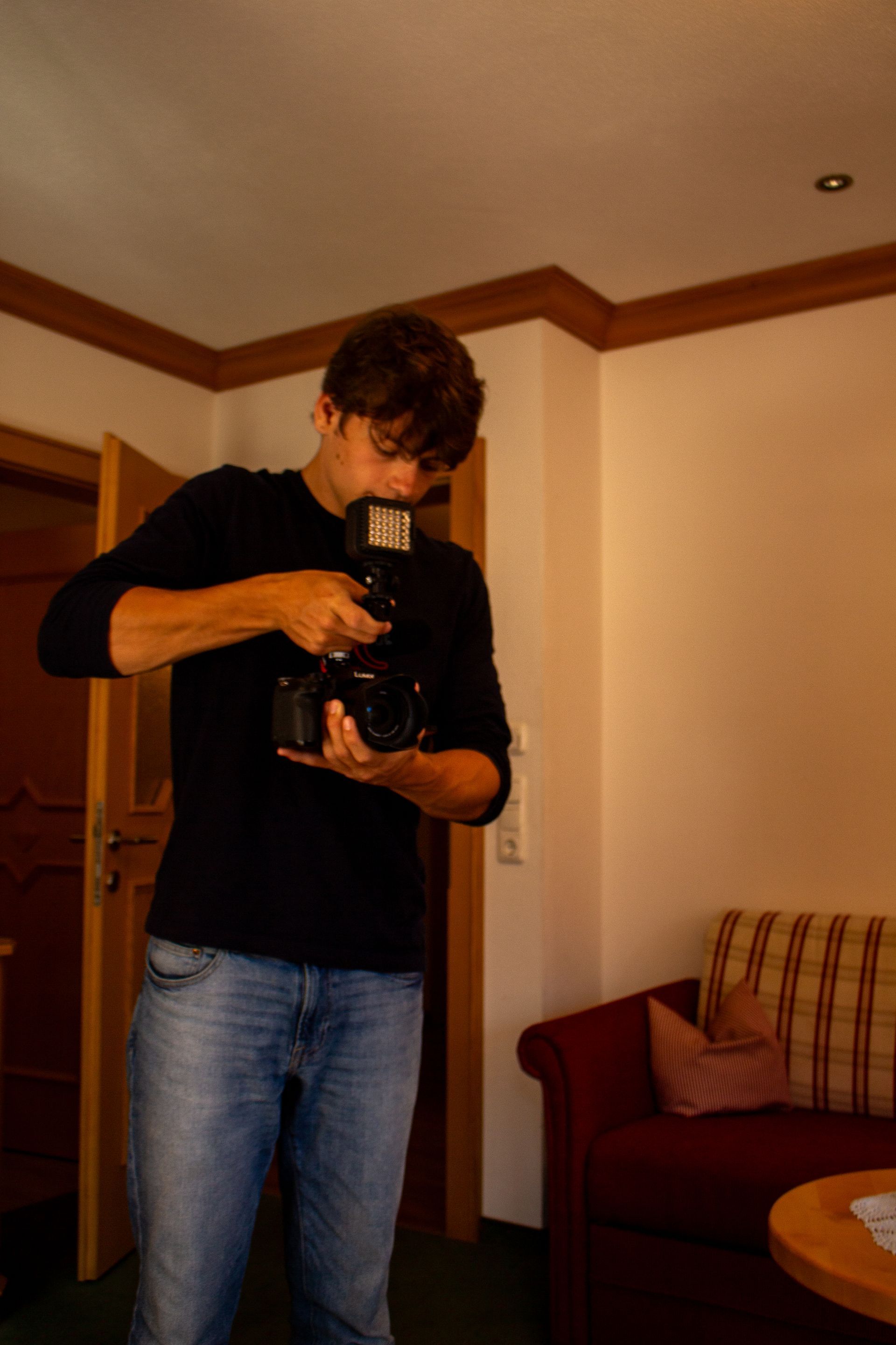 A man taking a picture with a camera in a living room