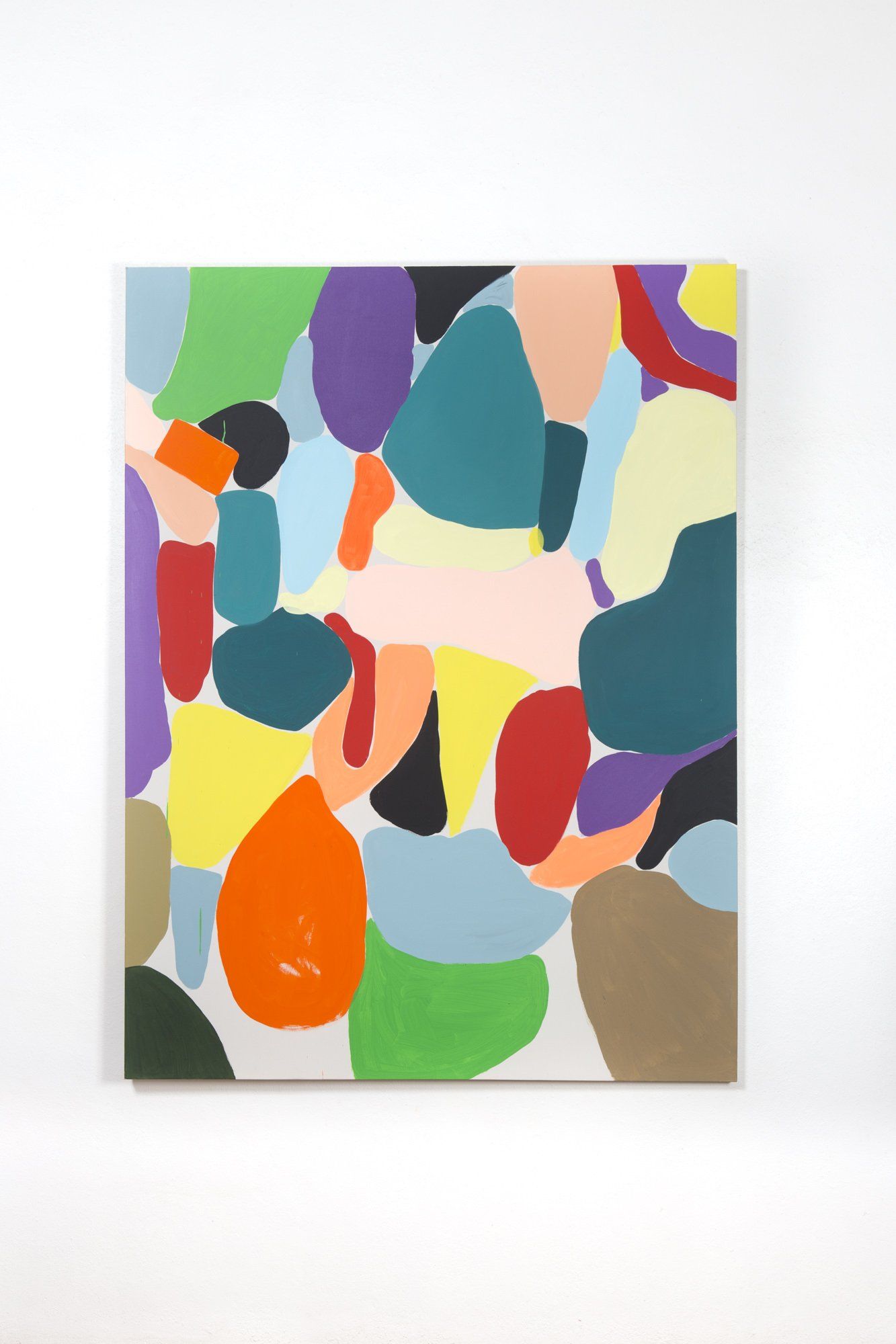 A colorful painting is hanging on a white wall.