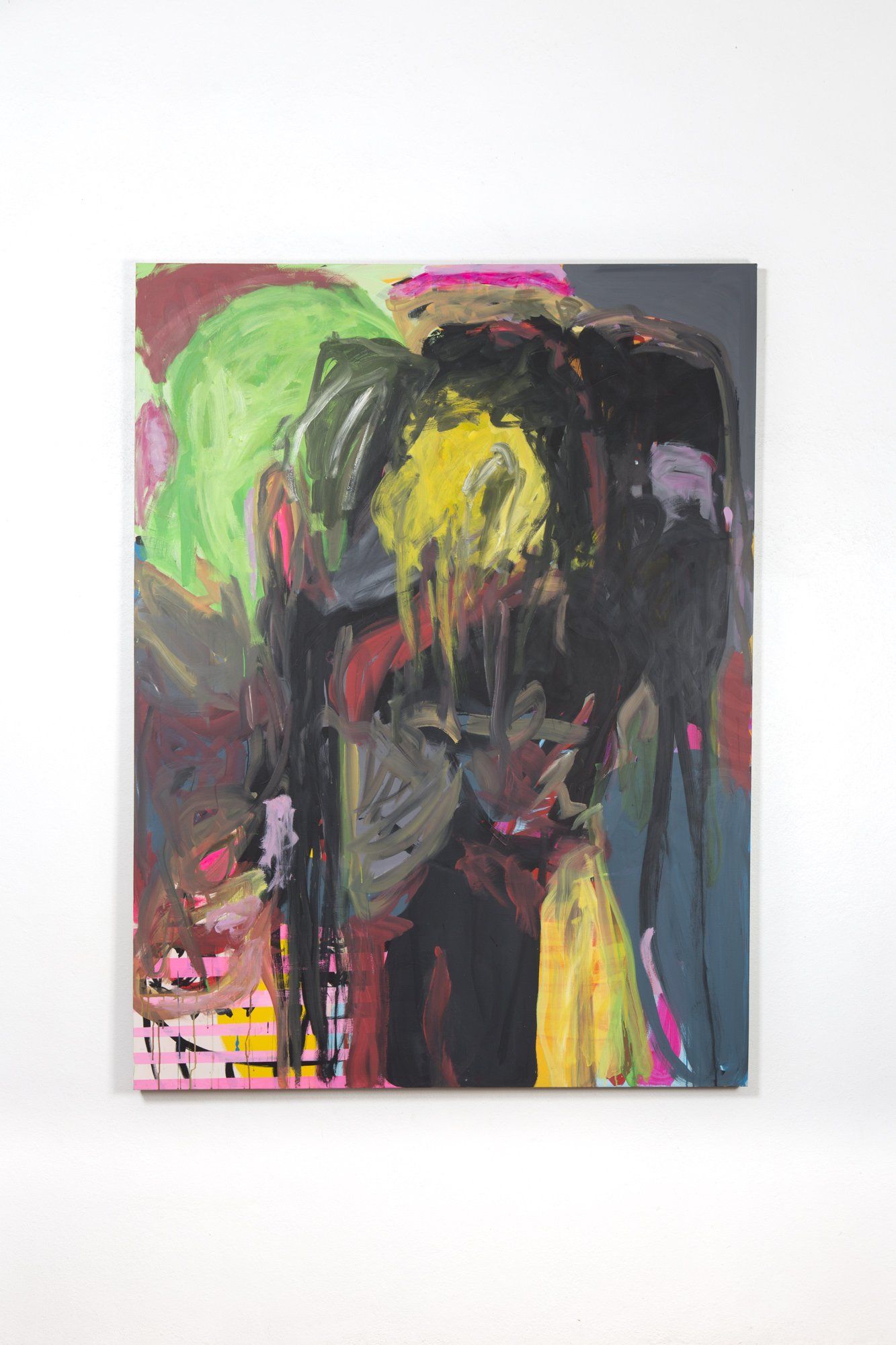 A colorful painting of a person 's face is hanging on a white wall.