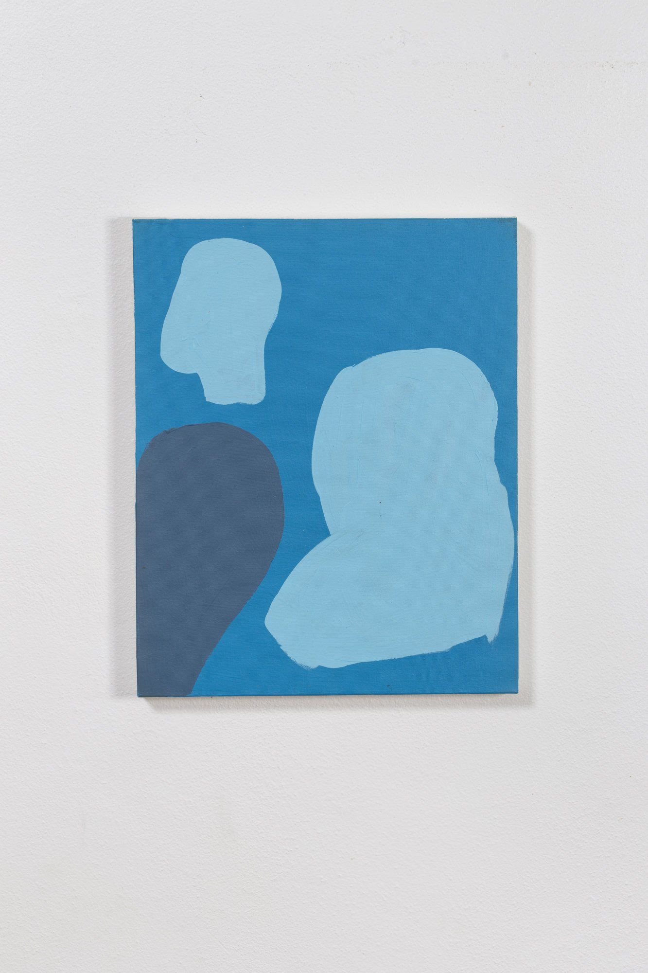 A blue and white painting on a white wall.