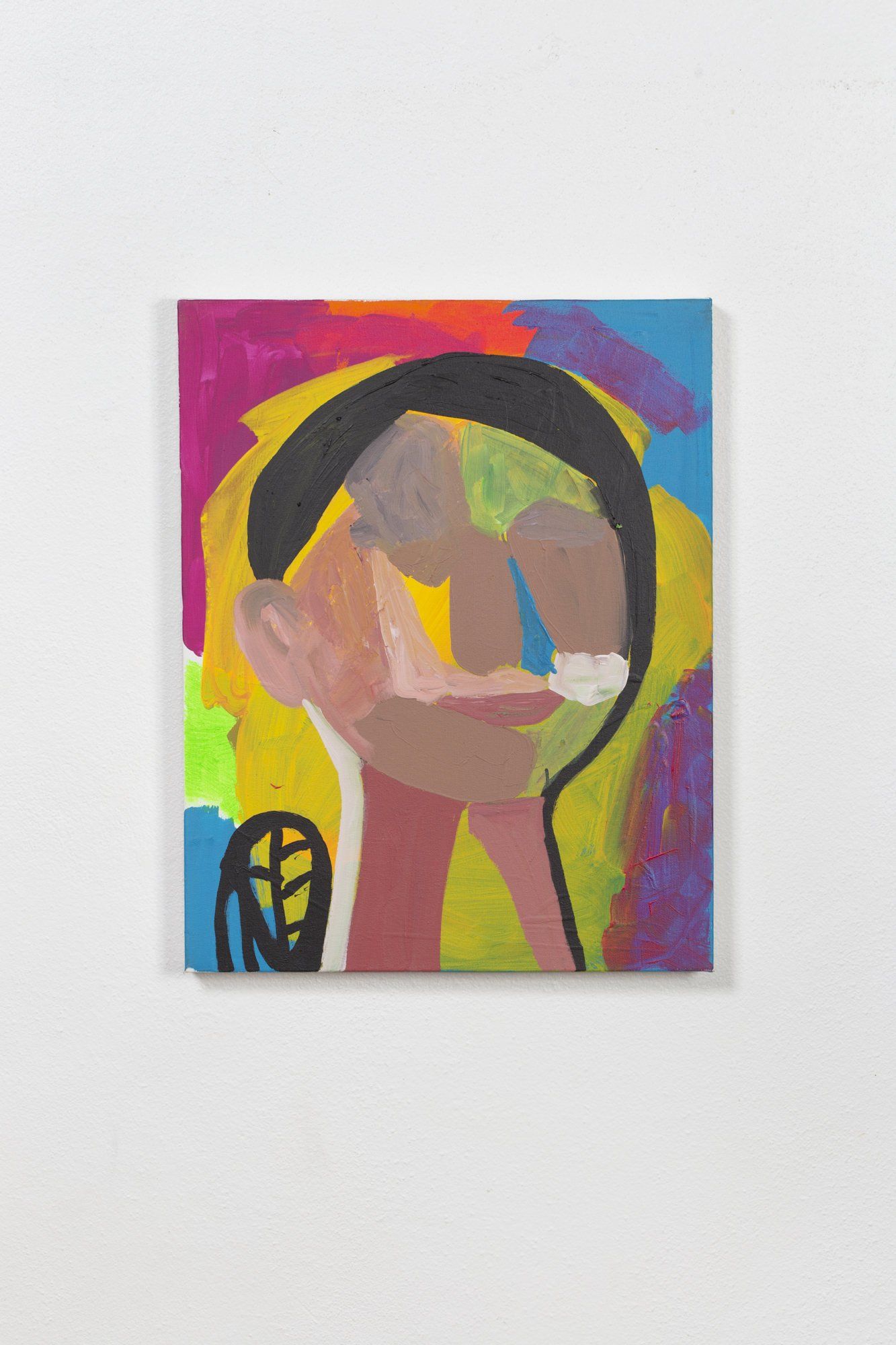 A colorful painting of a person 's head on a white wall.