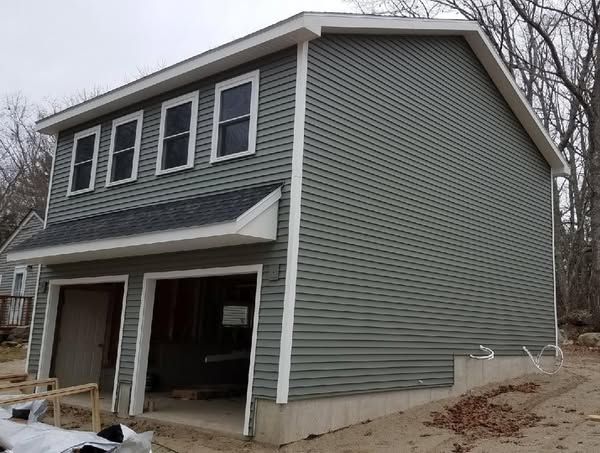 A green house with a garage underneath it