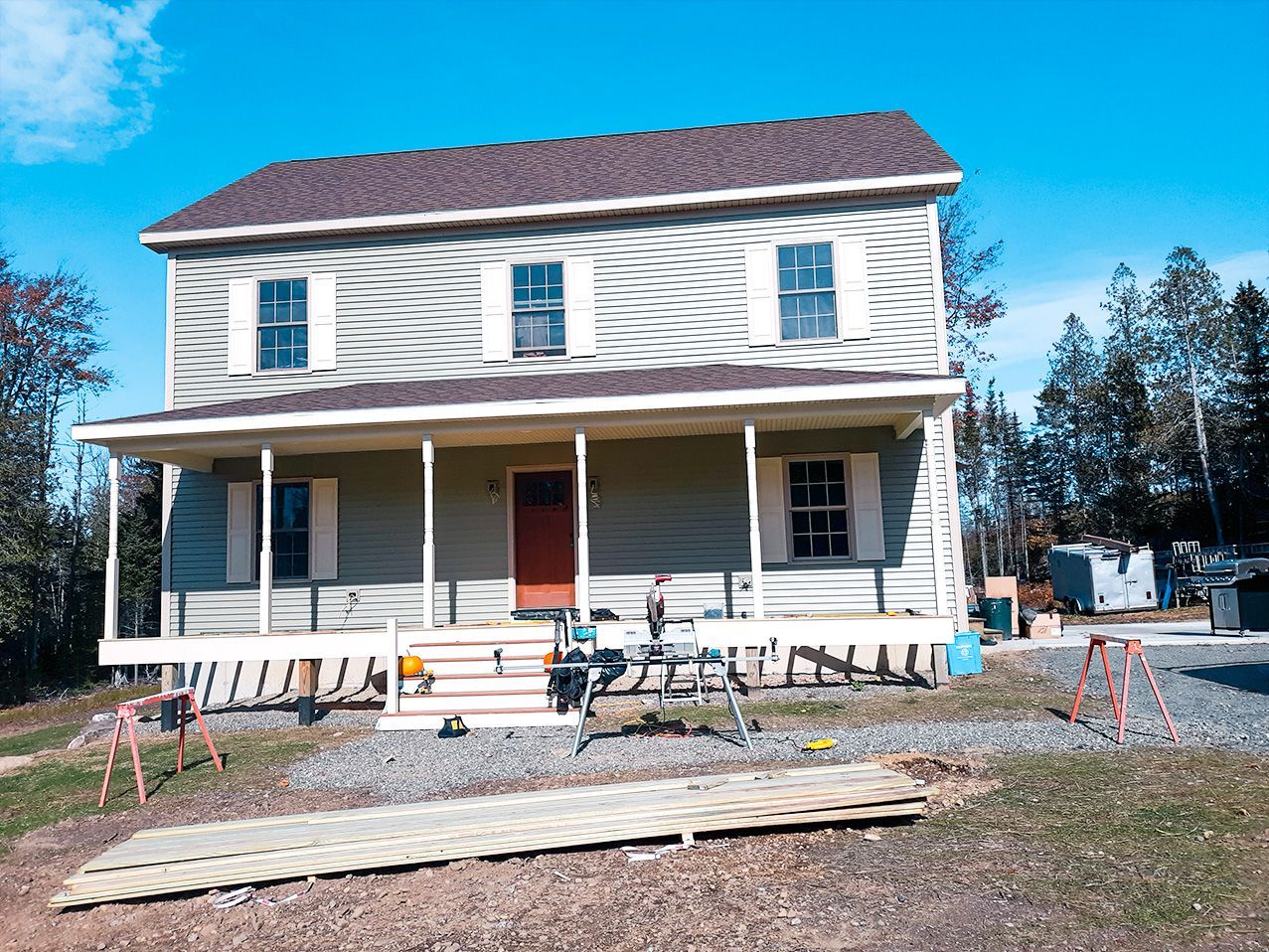 A large house with a porch is being built.