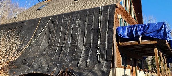 A large tarp is covering the side of a house.