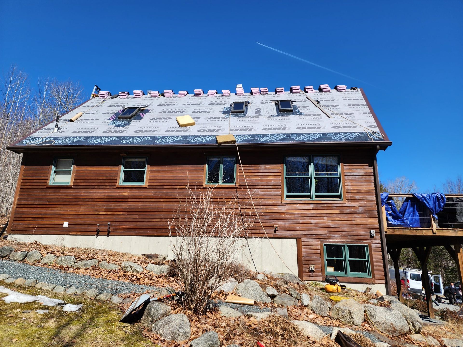 A wooden house with a roof that is being installed
