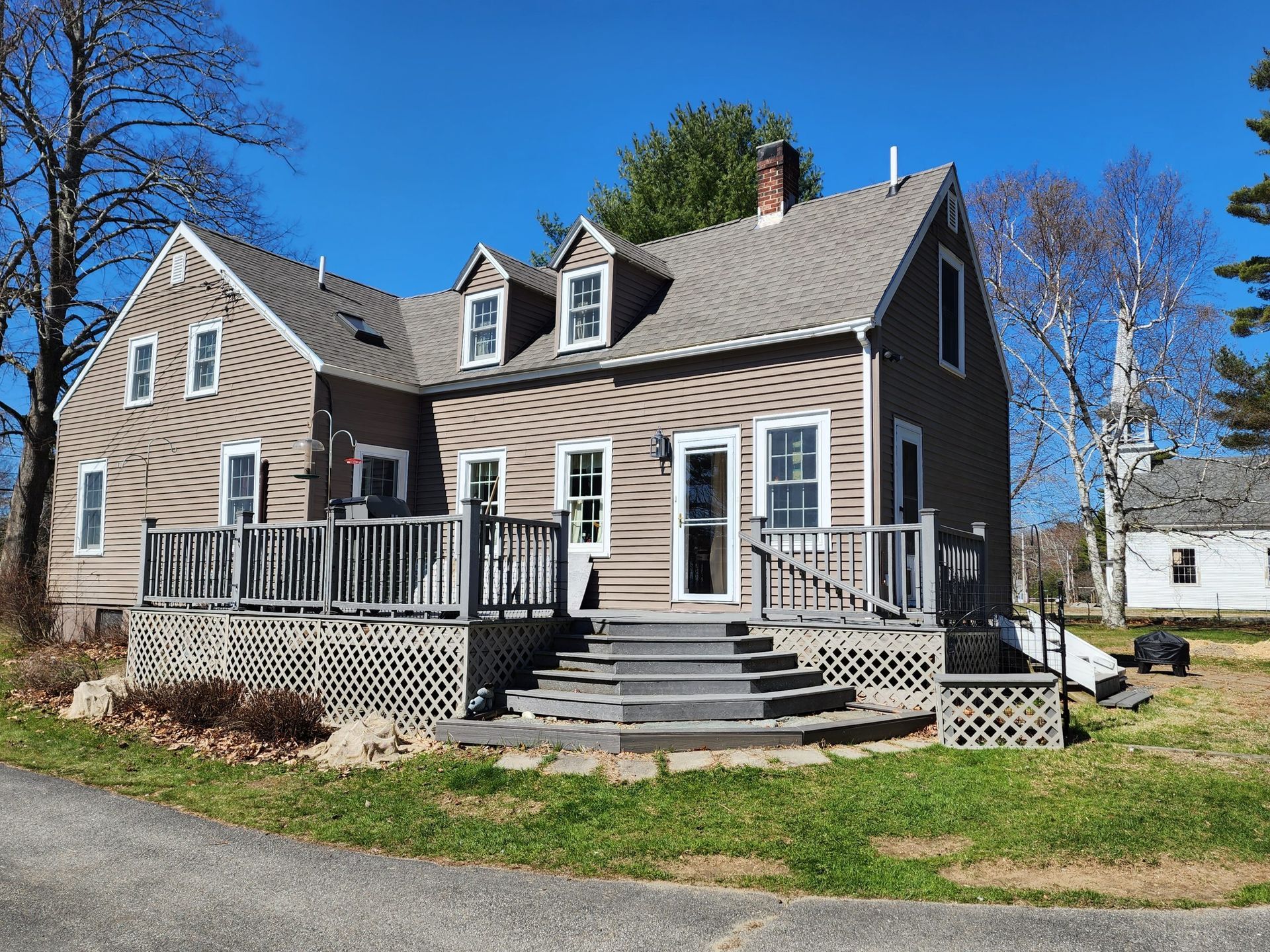 A large house with a large deck and stairs in front of it.