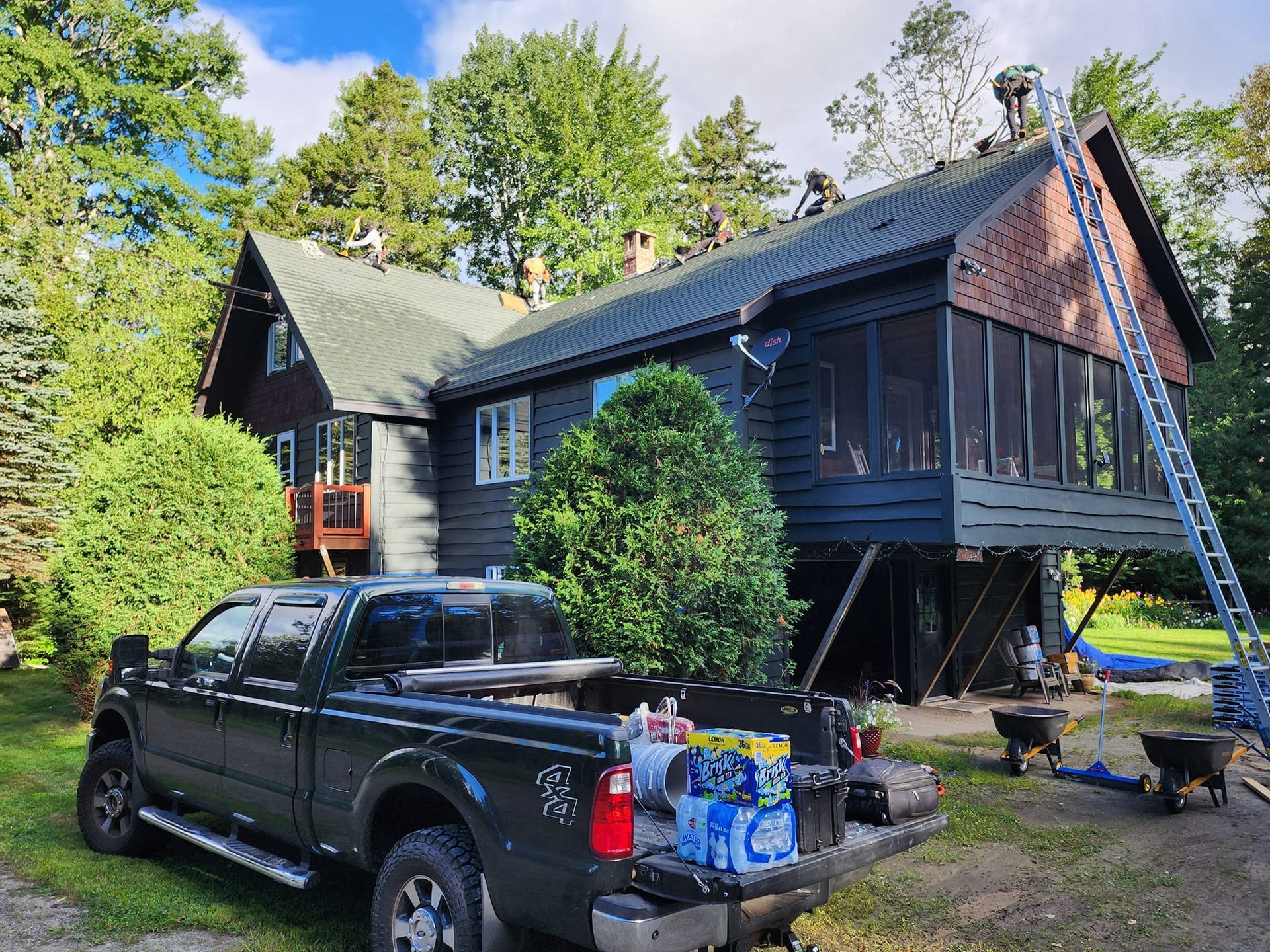 A truck is parked in front of a house that is being painted.