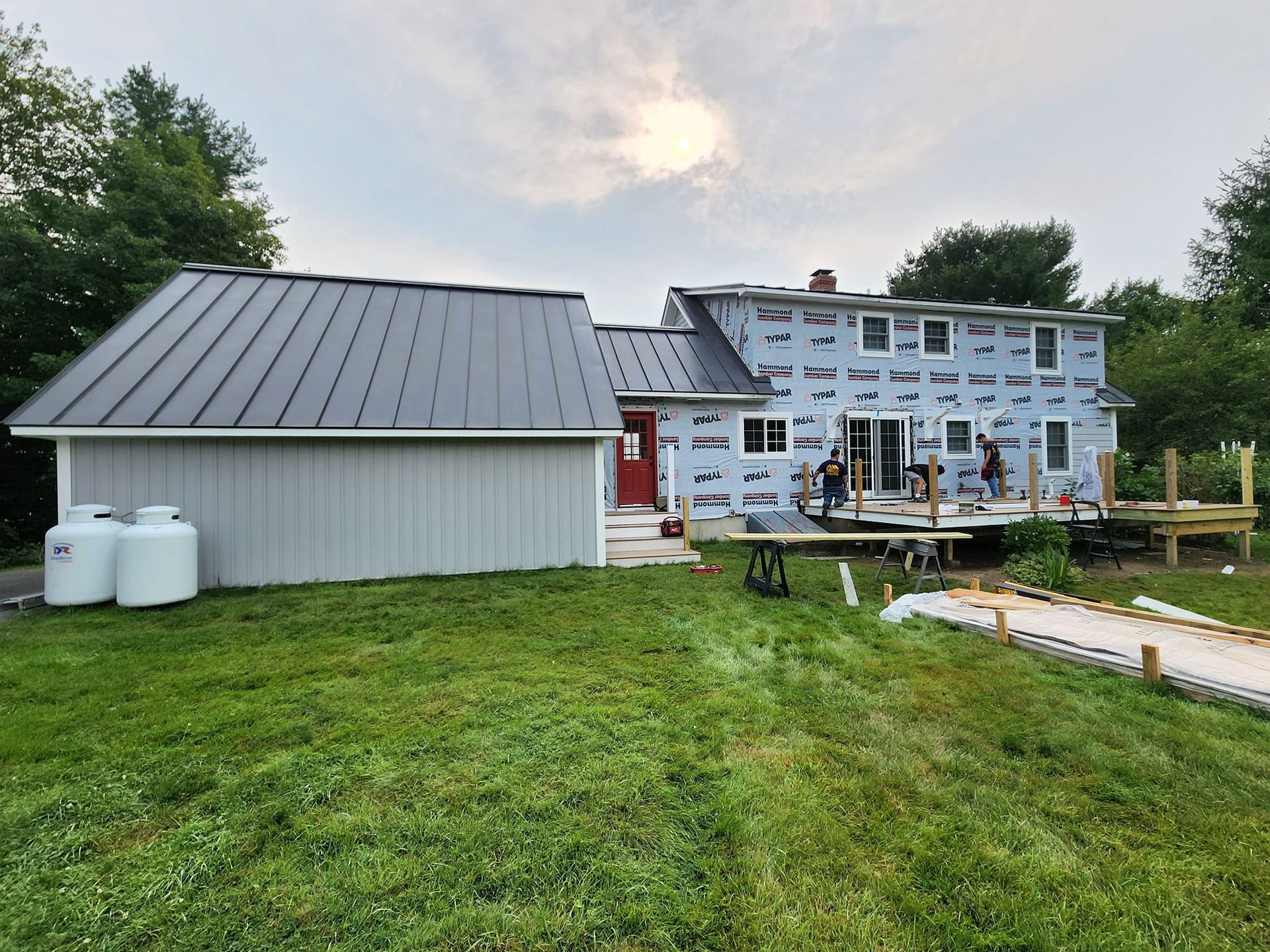 A house with a metal roof and a garage is being built.