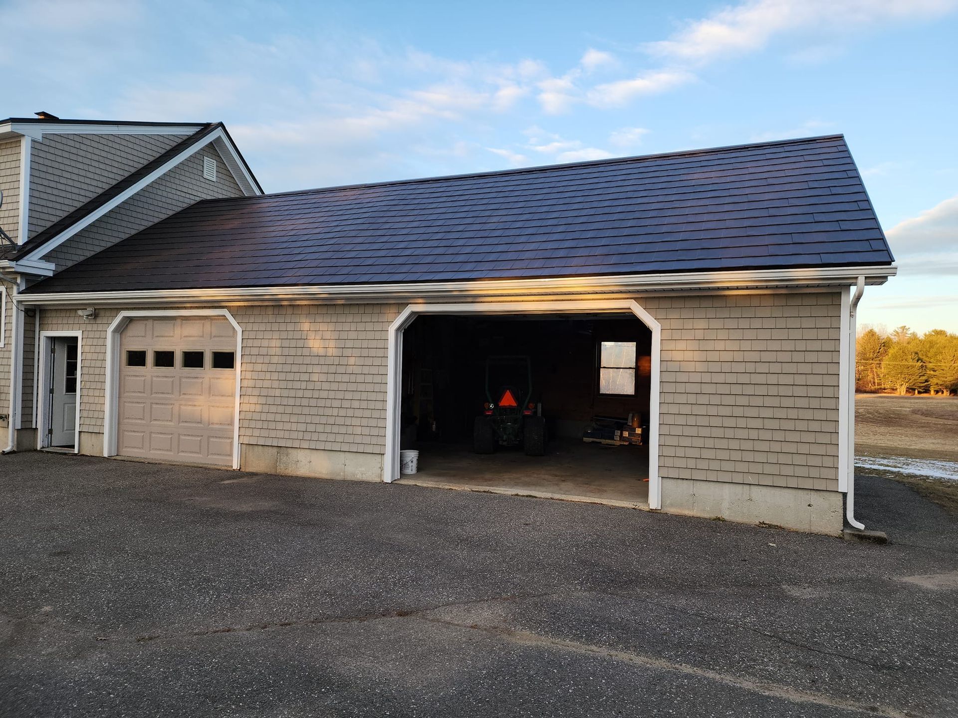 A garage with the doors open and a roof that looks like a barn.