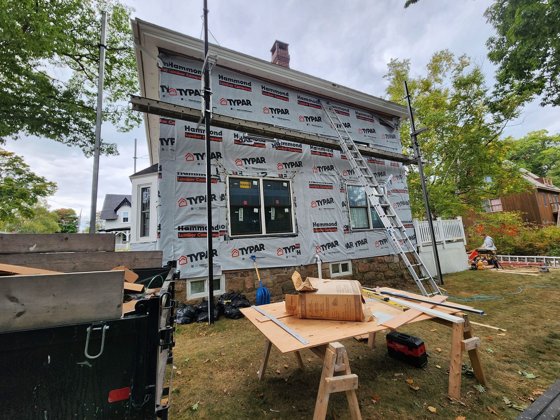 A house is being remodeled with a table in front of it.
