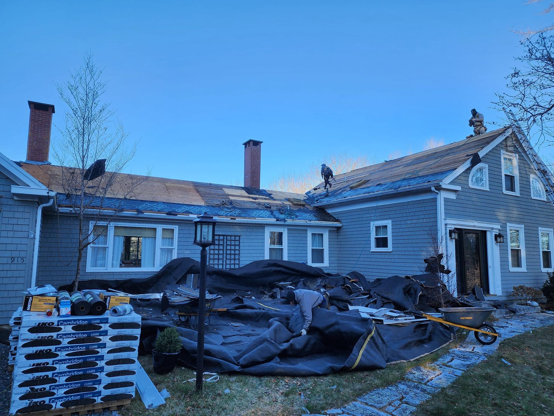 A group of people are working on the roof of a house.