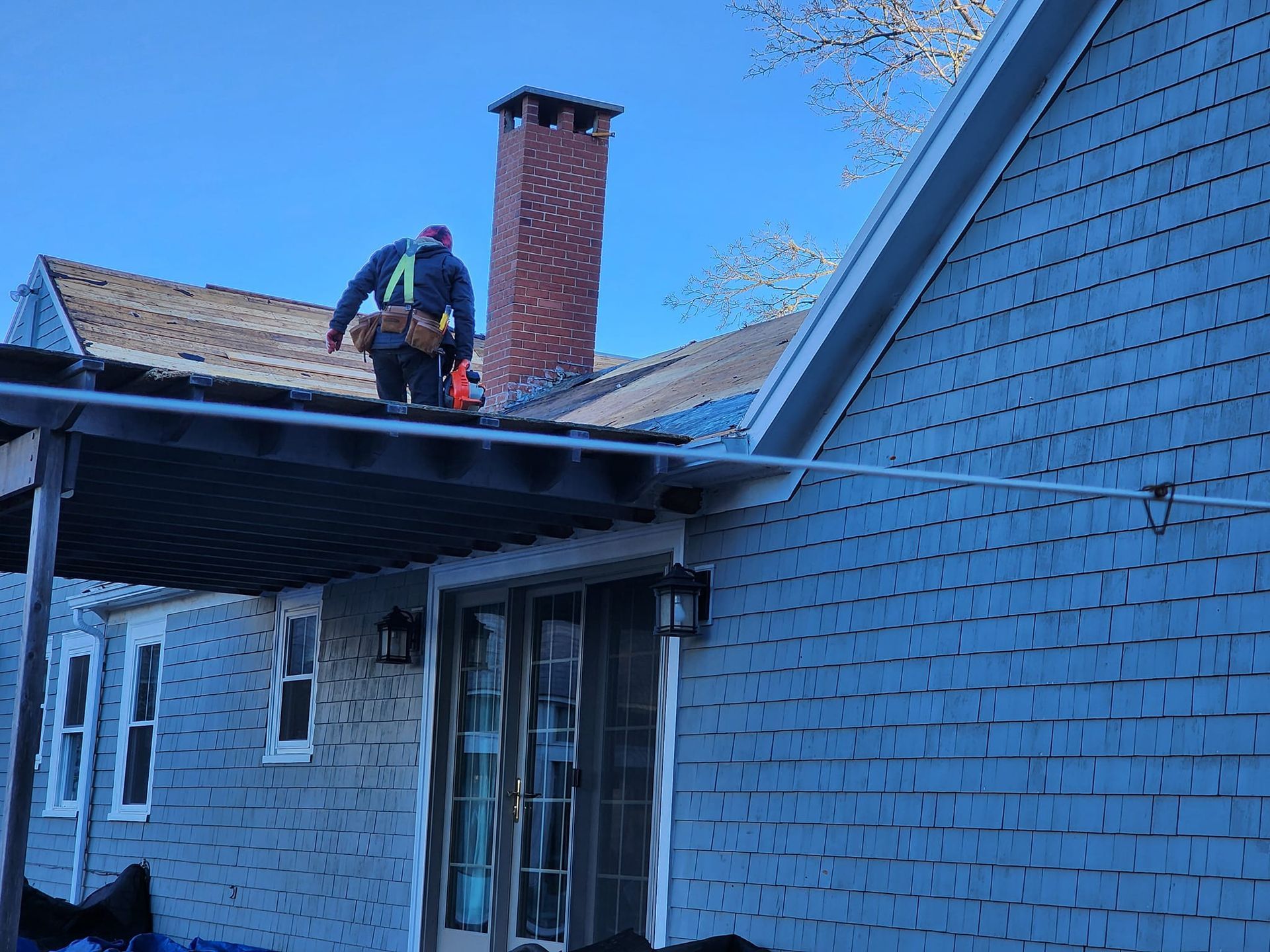 A man is working on the roof of a house.