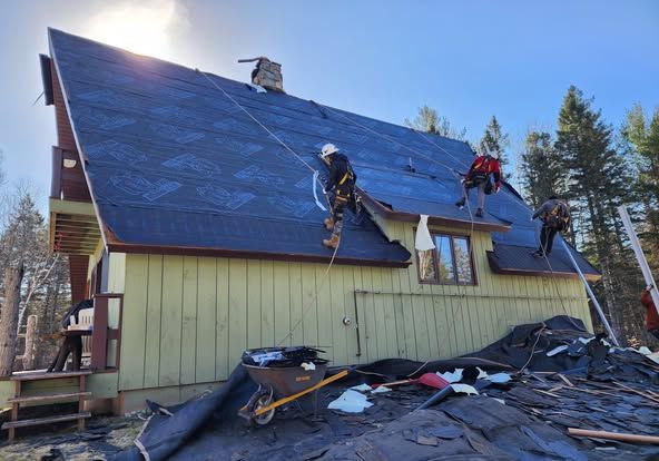 A group of people are working on the roof of a house.