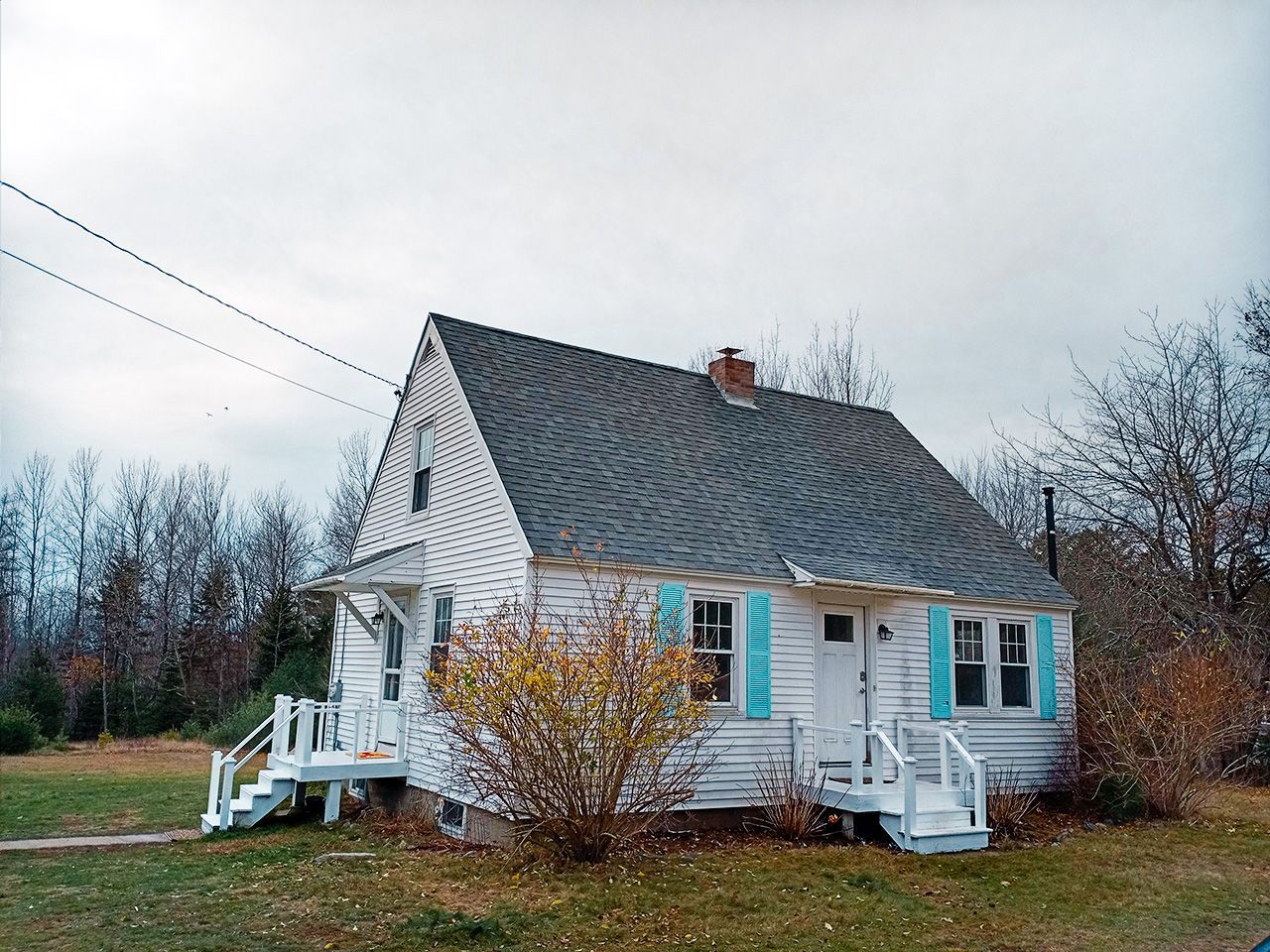 A small white house with blue shutters on the windows