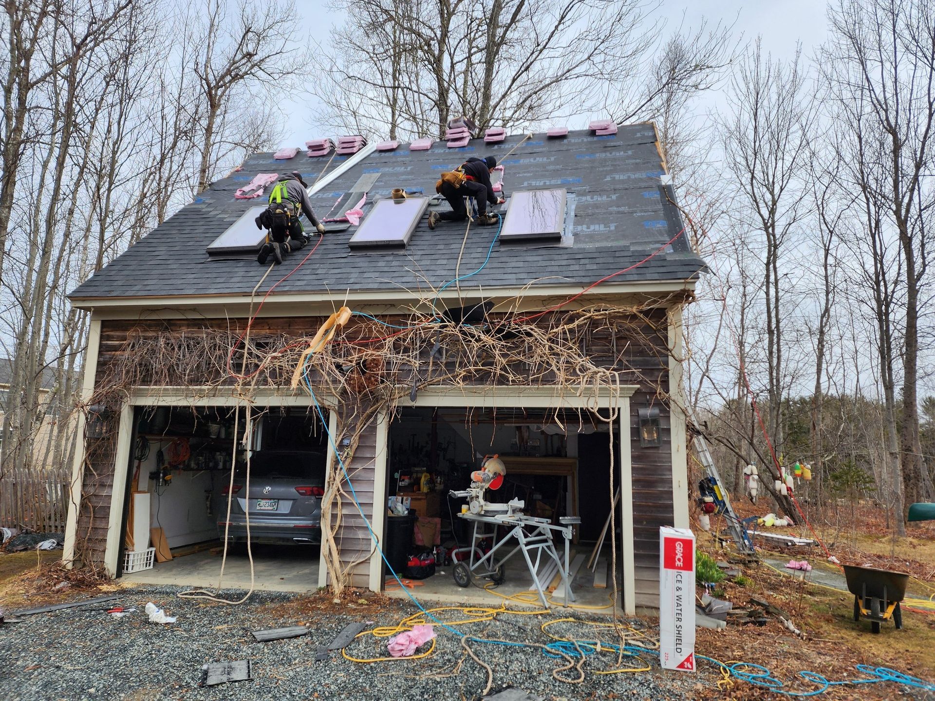 A couple of men are working on the roof of a garage.