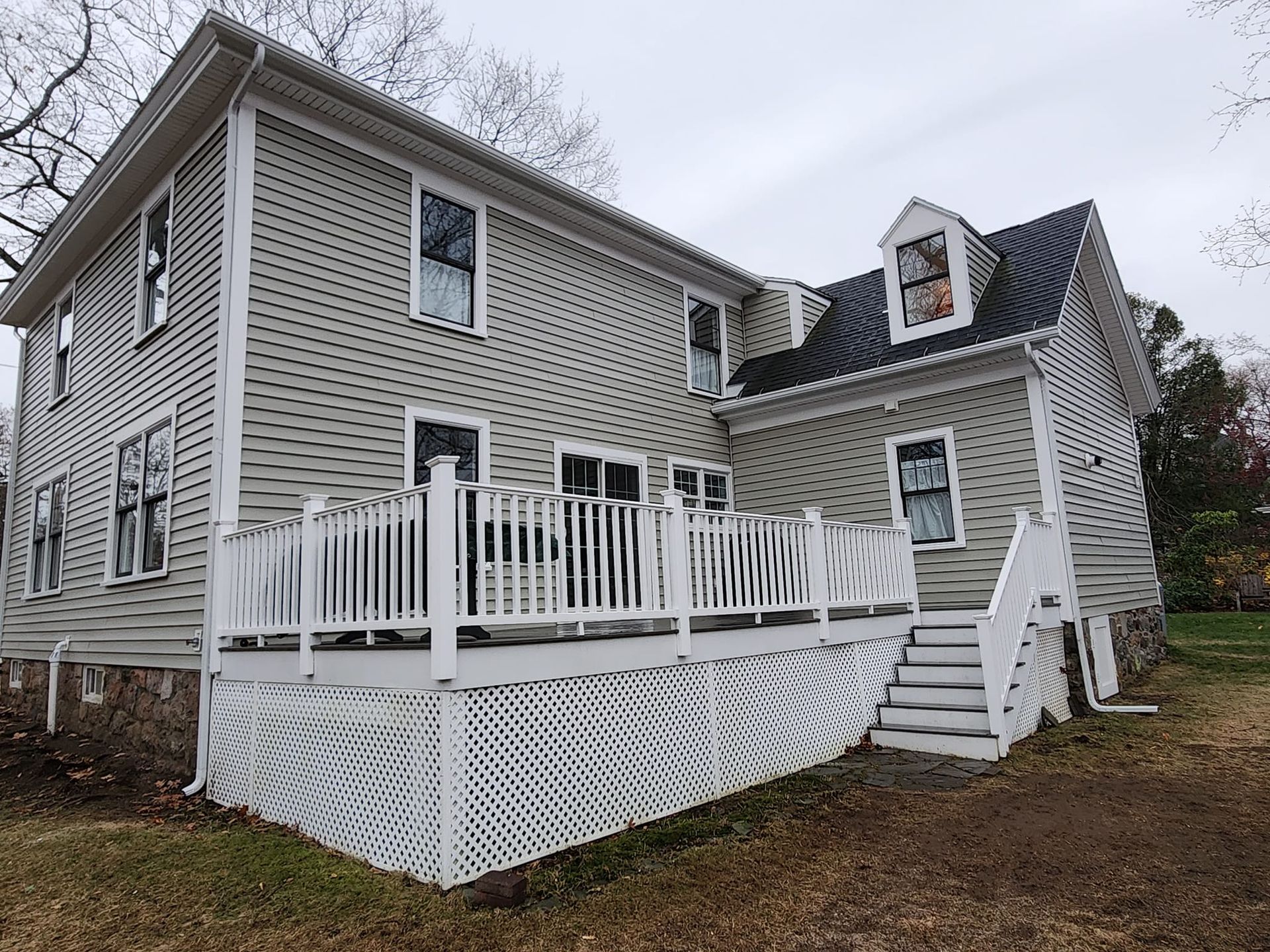 The back of a house with a large deck and stairs.