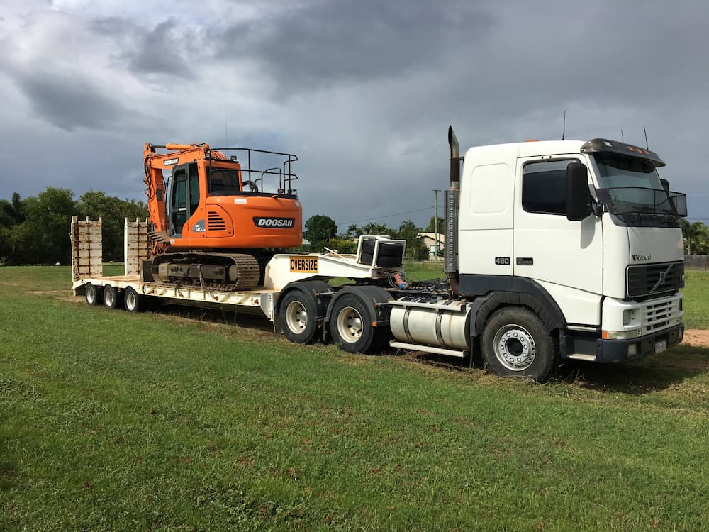 Mini Excavator Transported by Trailer Truck — Riley Earthmoving in Deeragun, QLD