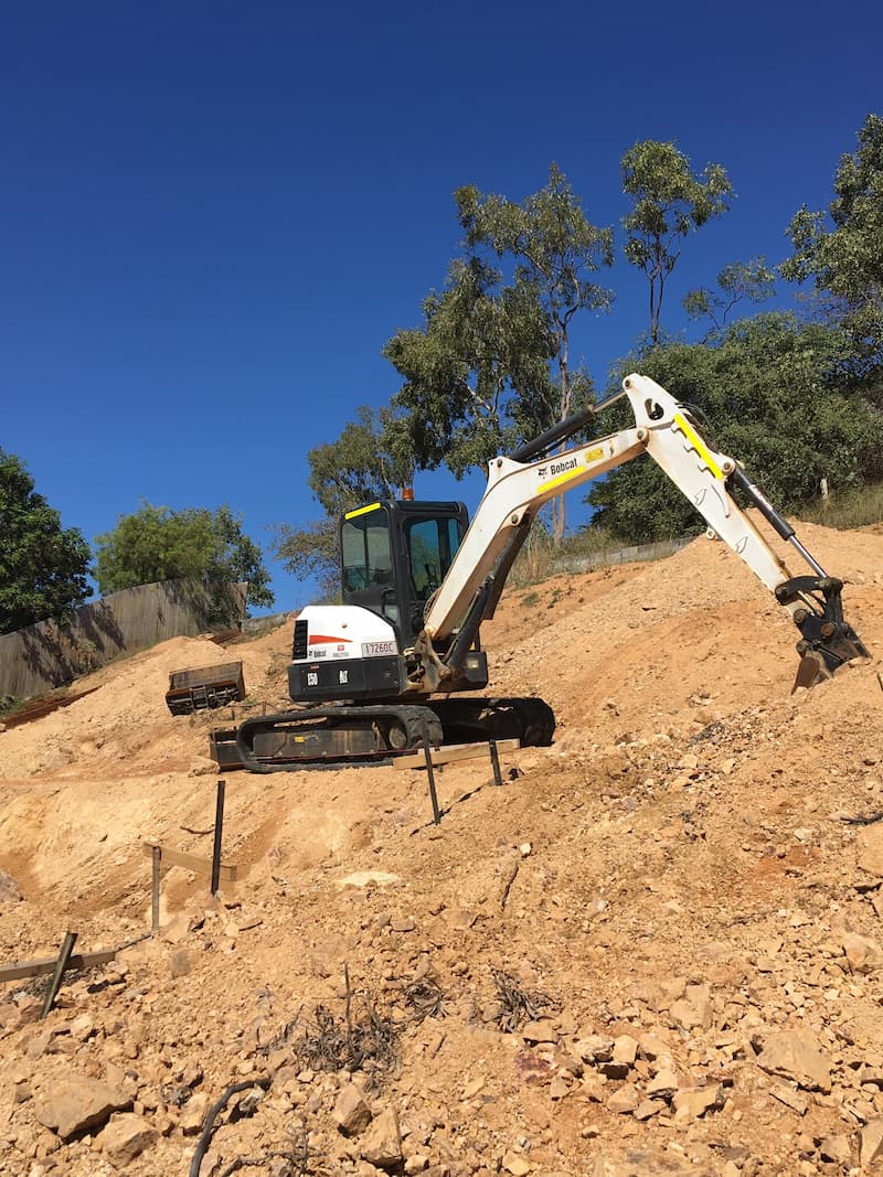 White Bobcat Excavator Digging on the Slope — Riley Earthmoving in Deeragun, QLD