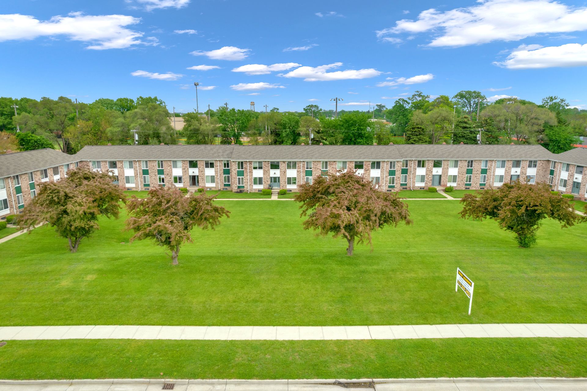 Building complex photo with courtyard of trees in the foreground