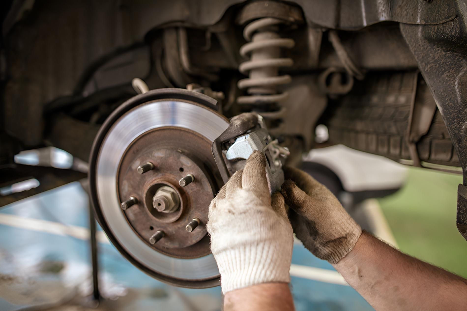 A Person Is Working On A Brake Disc On A Car — Brake & Clutch Automotive Services In Ciccone, NT
