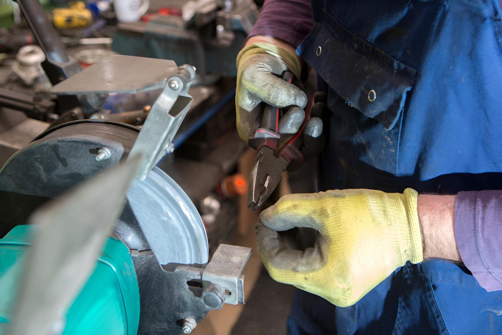 A Person Wearing Yellow Gloves Is Working On A Machine — Brake & Clutch Automotive Services In Ciccone, NT