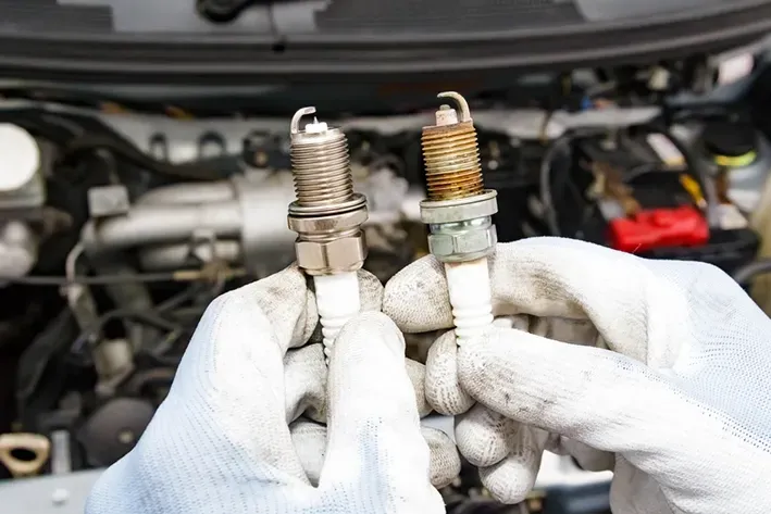 Mechanic Replacing Old Spark Plug With New — Brake & Clutch Automotive Services in Ciccone, NT