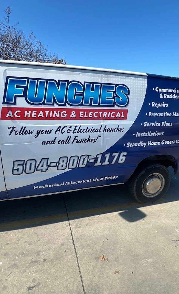 Electrician working on electrical panel, wearing gloves, hardhat, and tool belt.