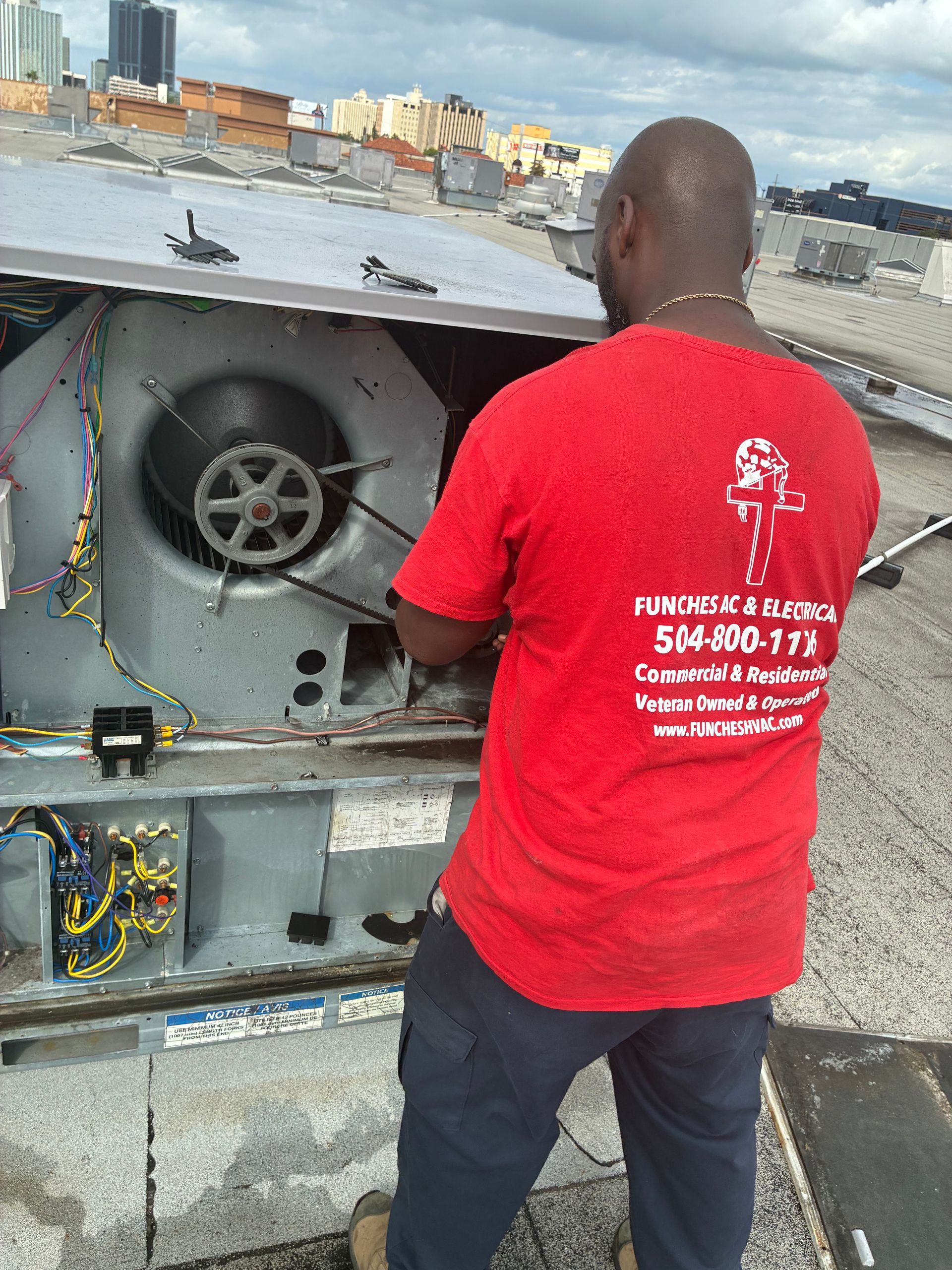 An air conditioning unit with gauges and hoses is being serviced outdoors.
